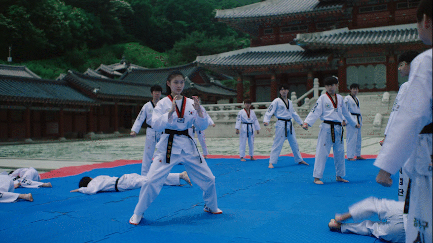 A person walks down a dimly lit alley at night.