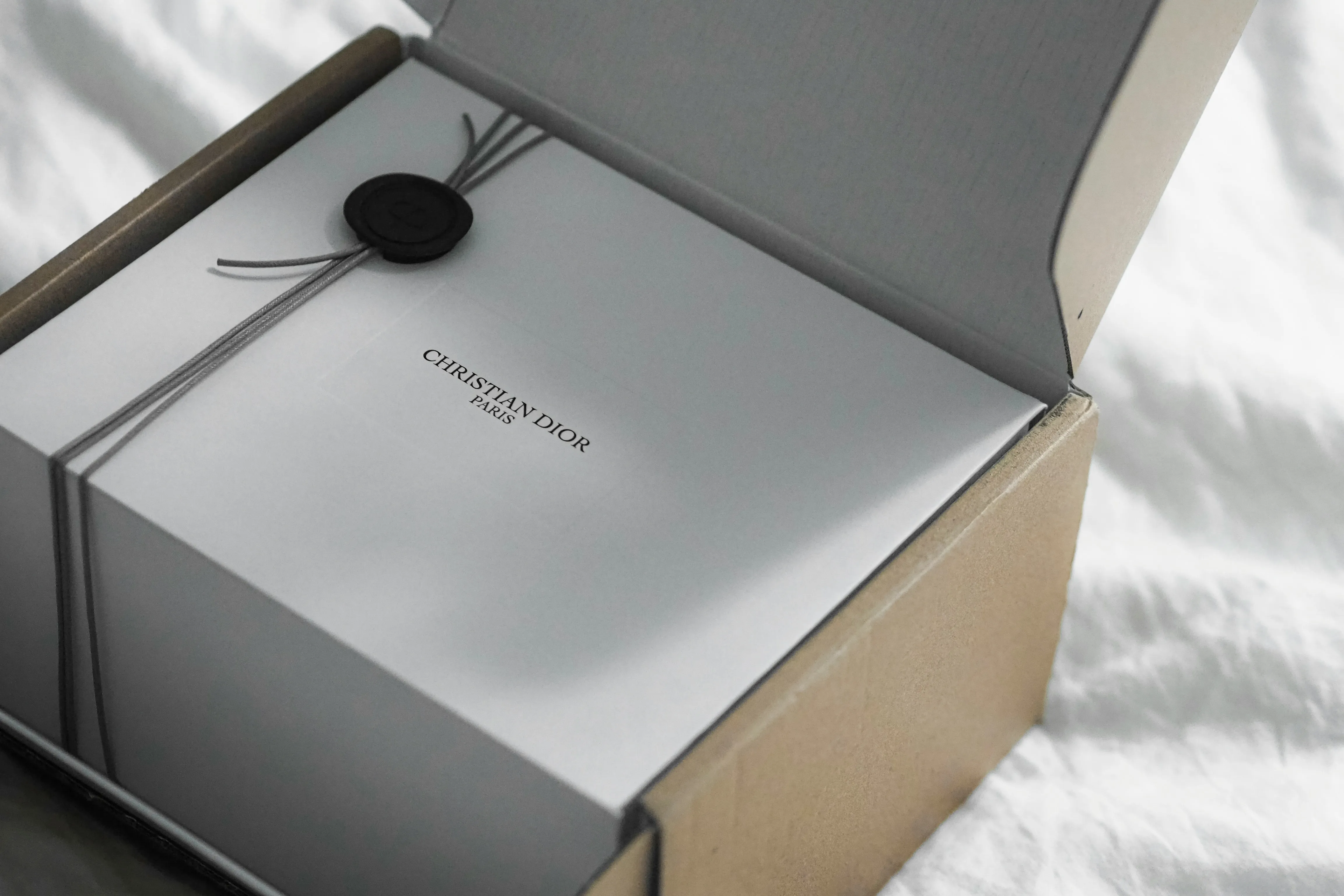 Dior gift box with ribbon and ribbon on white surface