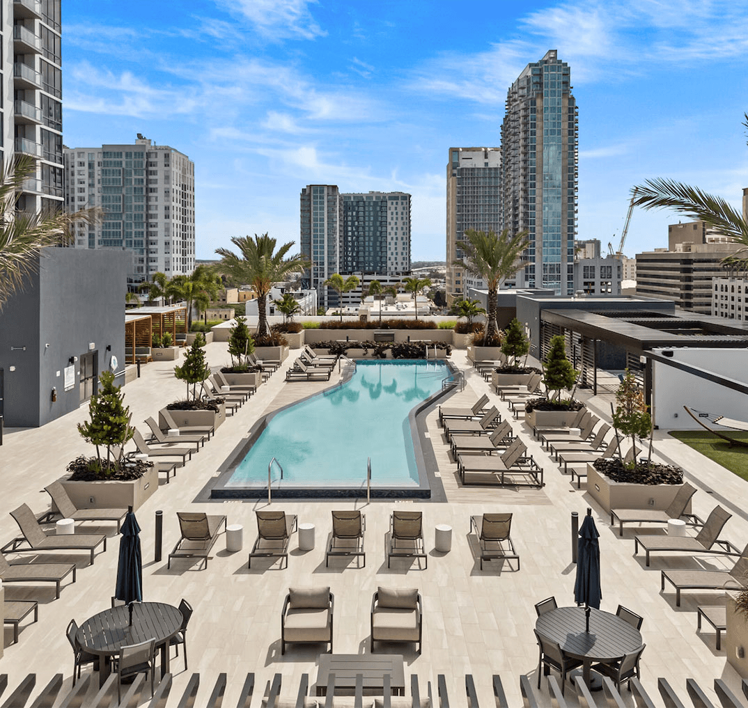 Rooftop pool area at AER Tampa with lounge seating and views of Tampa skyline