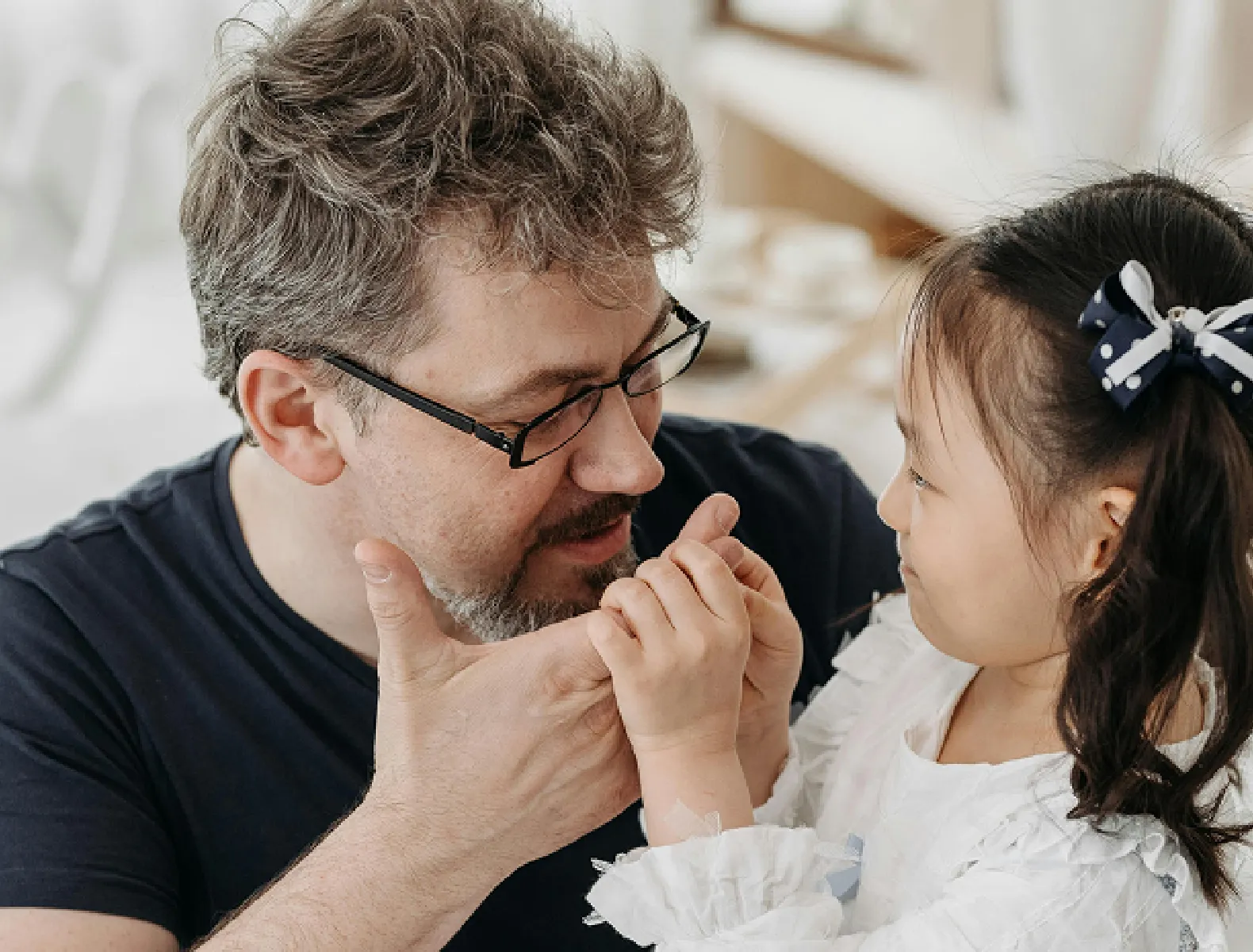 A man with his daughter sitting on his lap.