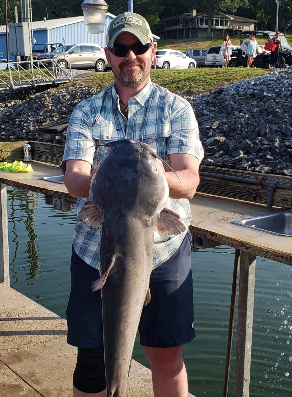 Person holding a fish near a dock