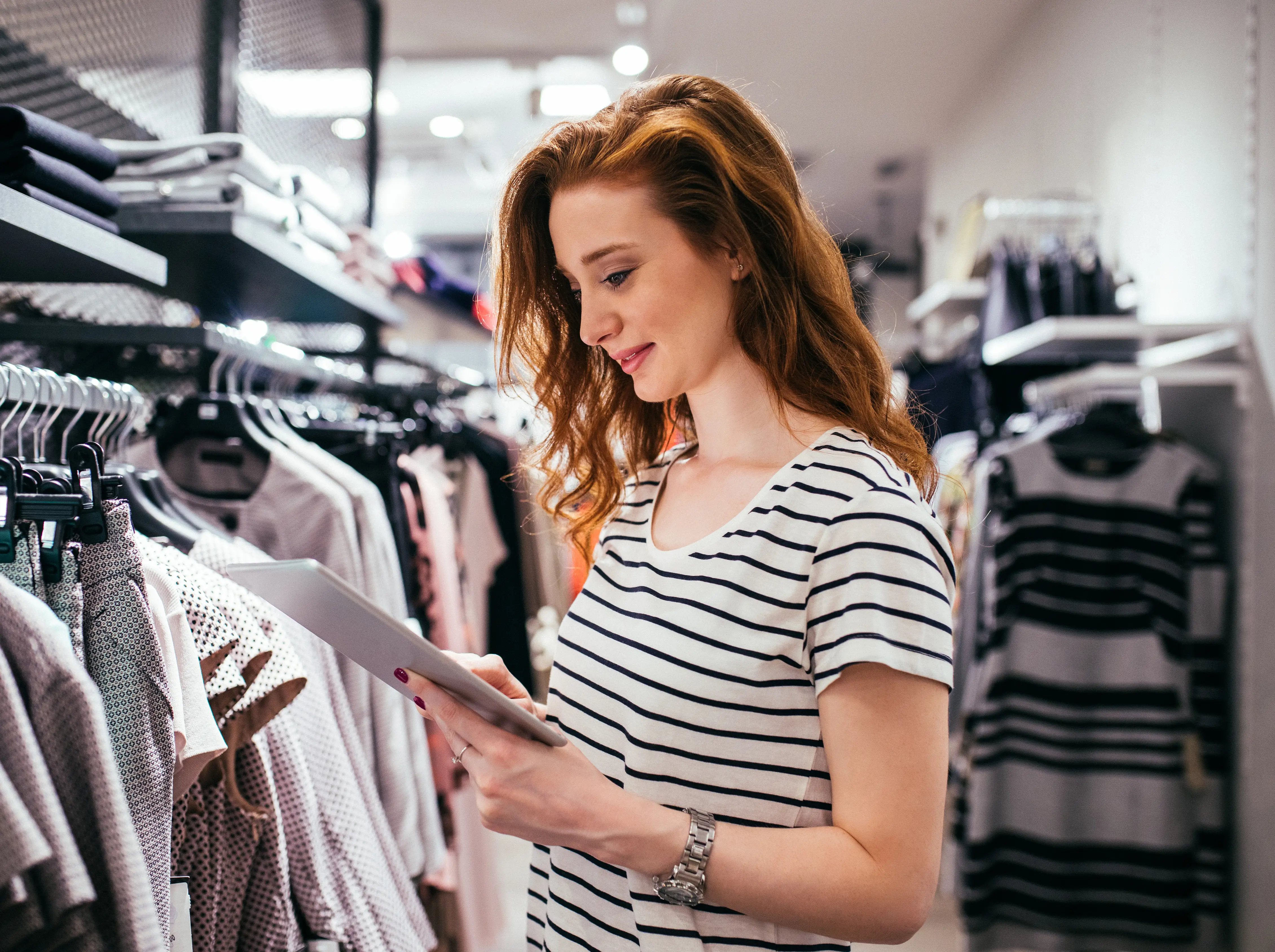 Woman using a tablet in a clothing store.