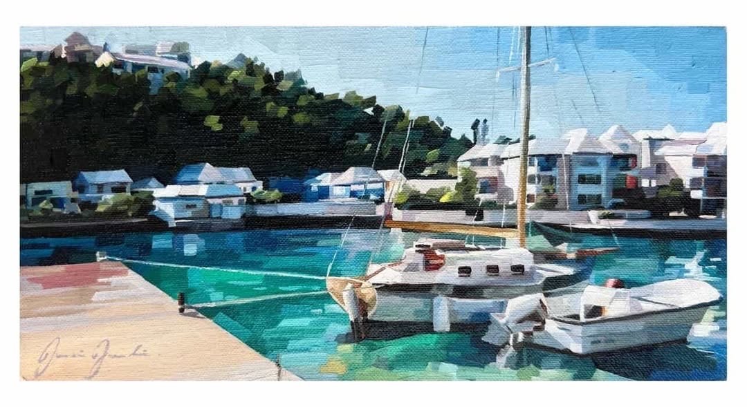 An impressionistic oil painting on canvas of Flatts Inlet in Bermuda by artist Jasmine Jardine. Two small boats are moored in the foreground on geometric, blocky water painted in shades of vibrant turquoise, emerald, and cerulean blue. In the background, white-roofed Bermudian houses sit along the waterfront at the base of a steep, densely wooded green hillside under a pale blue sky. Jasmine Jardine's signature is visible in the bottom-left corner.