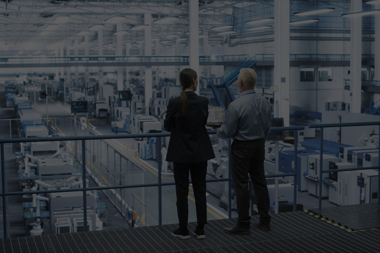 A business womand and man standing in an industrial looking warehouse