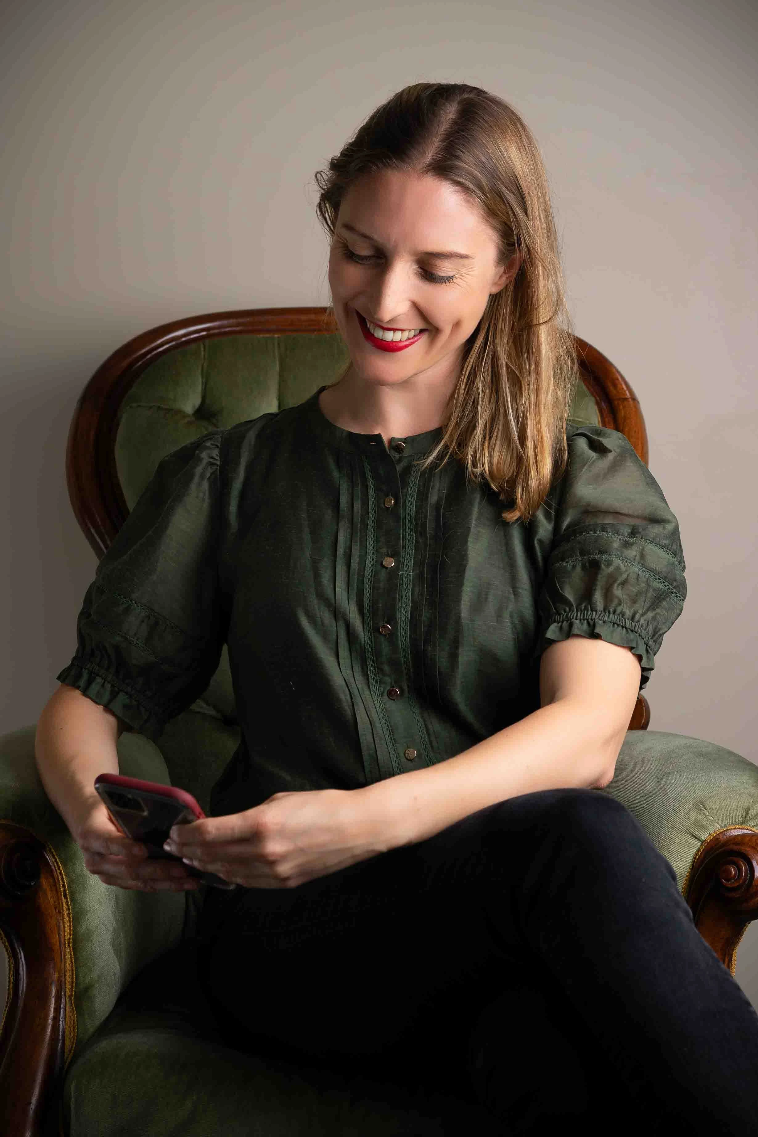 Melanie looking at her phone helping a client with marketing