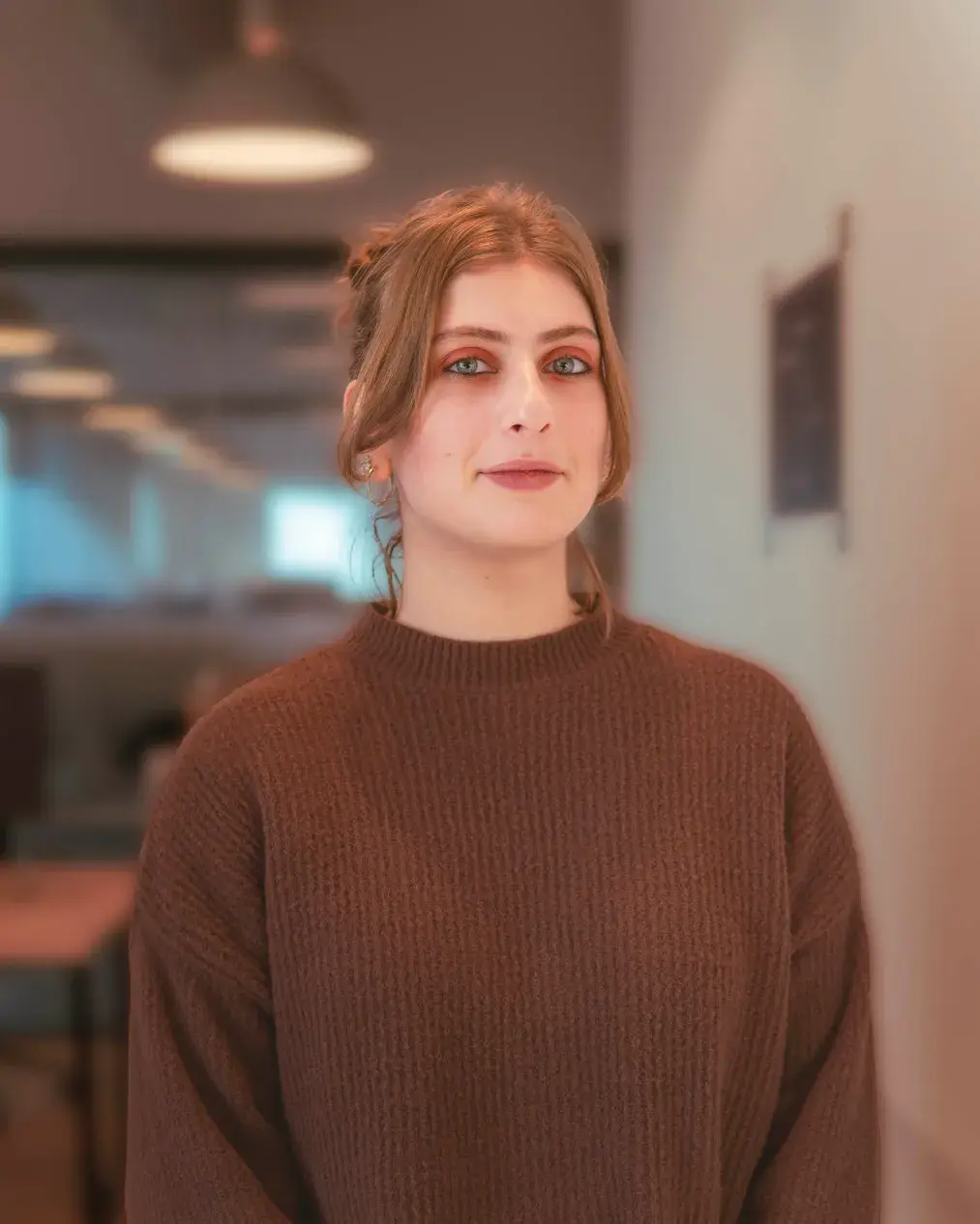 Woman in brown sweater looking at camera