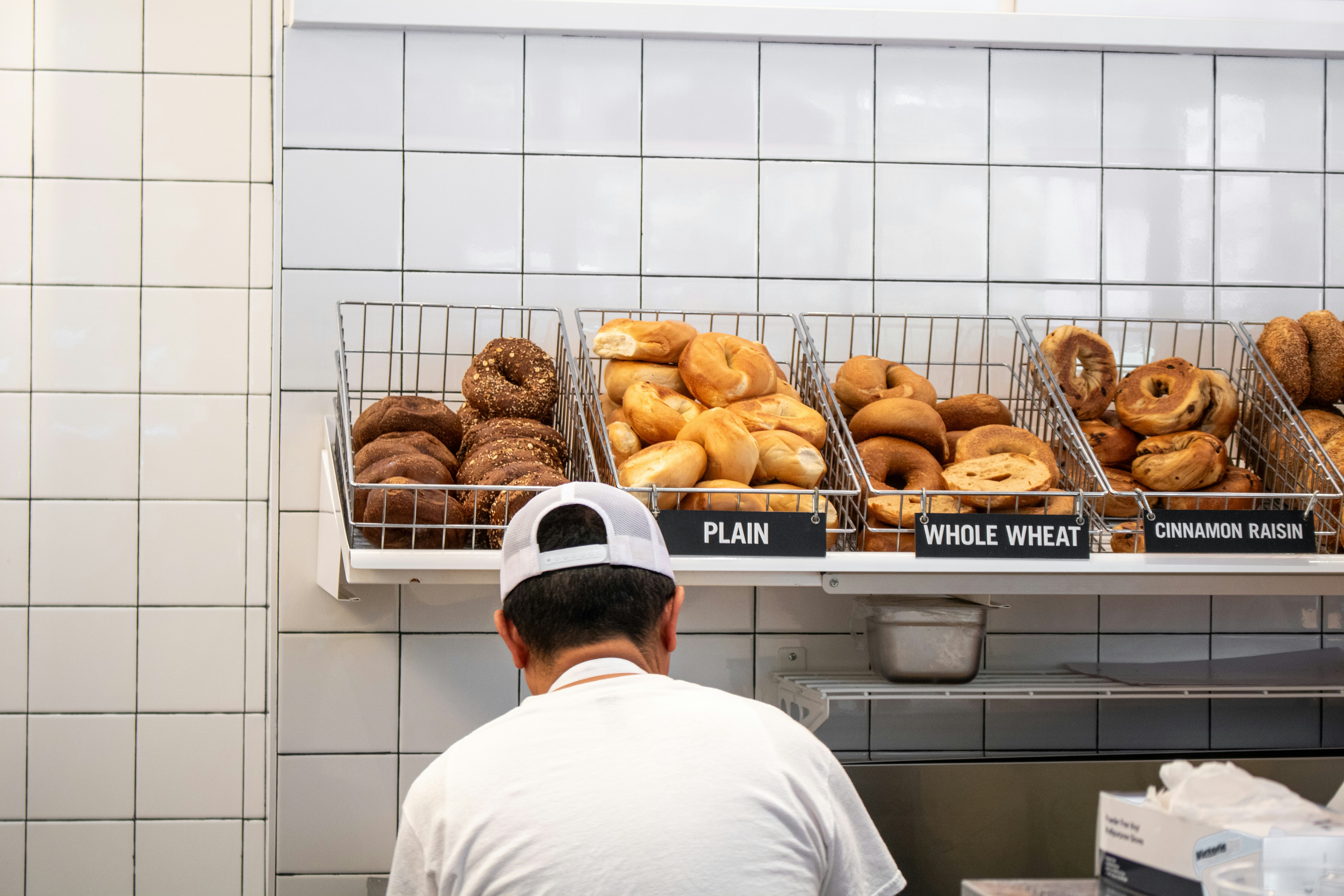 a man standing in front of a display of doughnuts