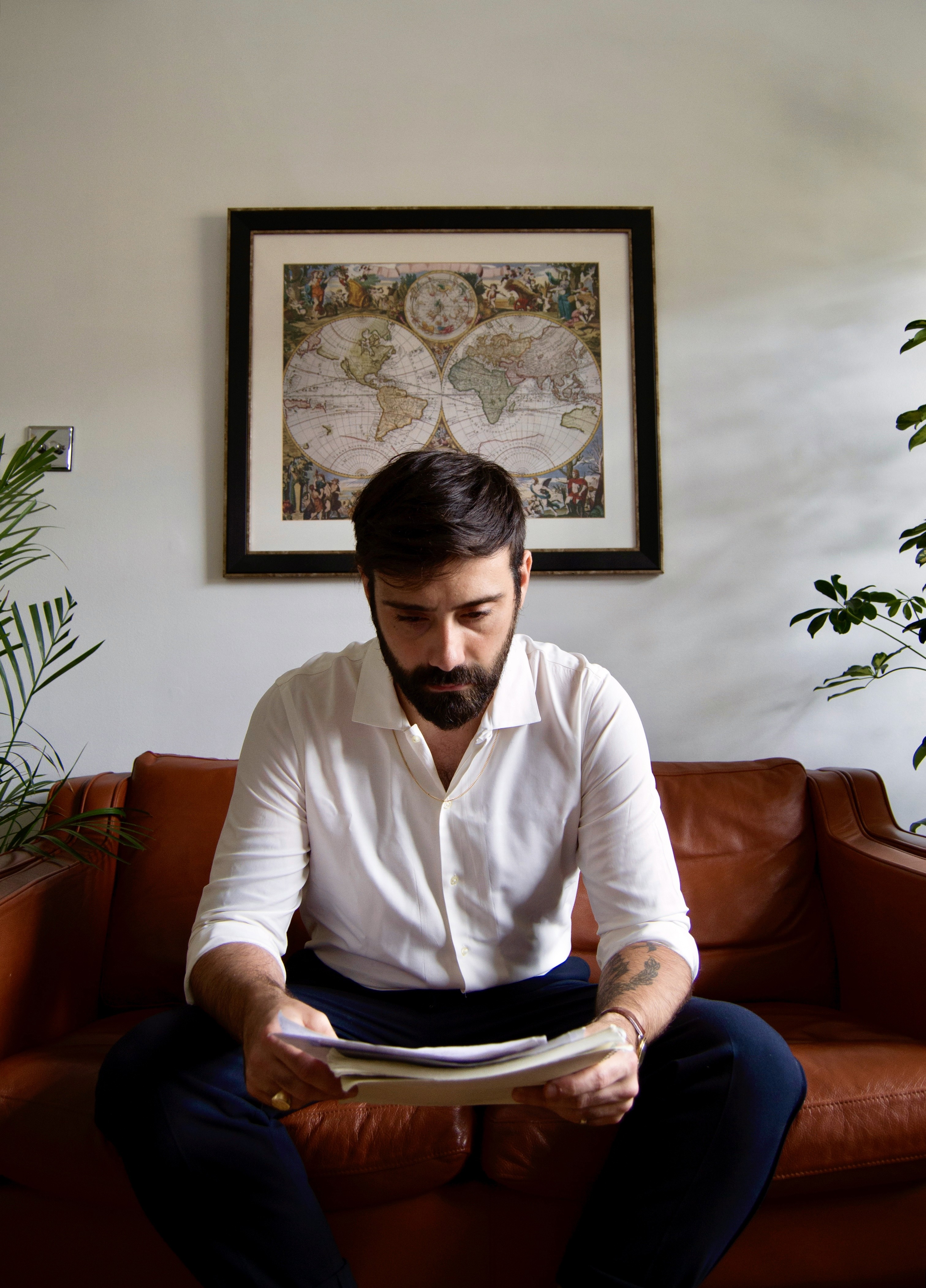 A thoughtful young person with dark hair gazes to the side, captured in soft black and white lighting.