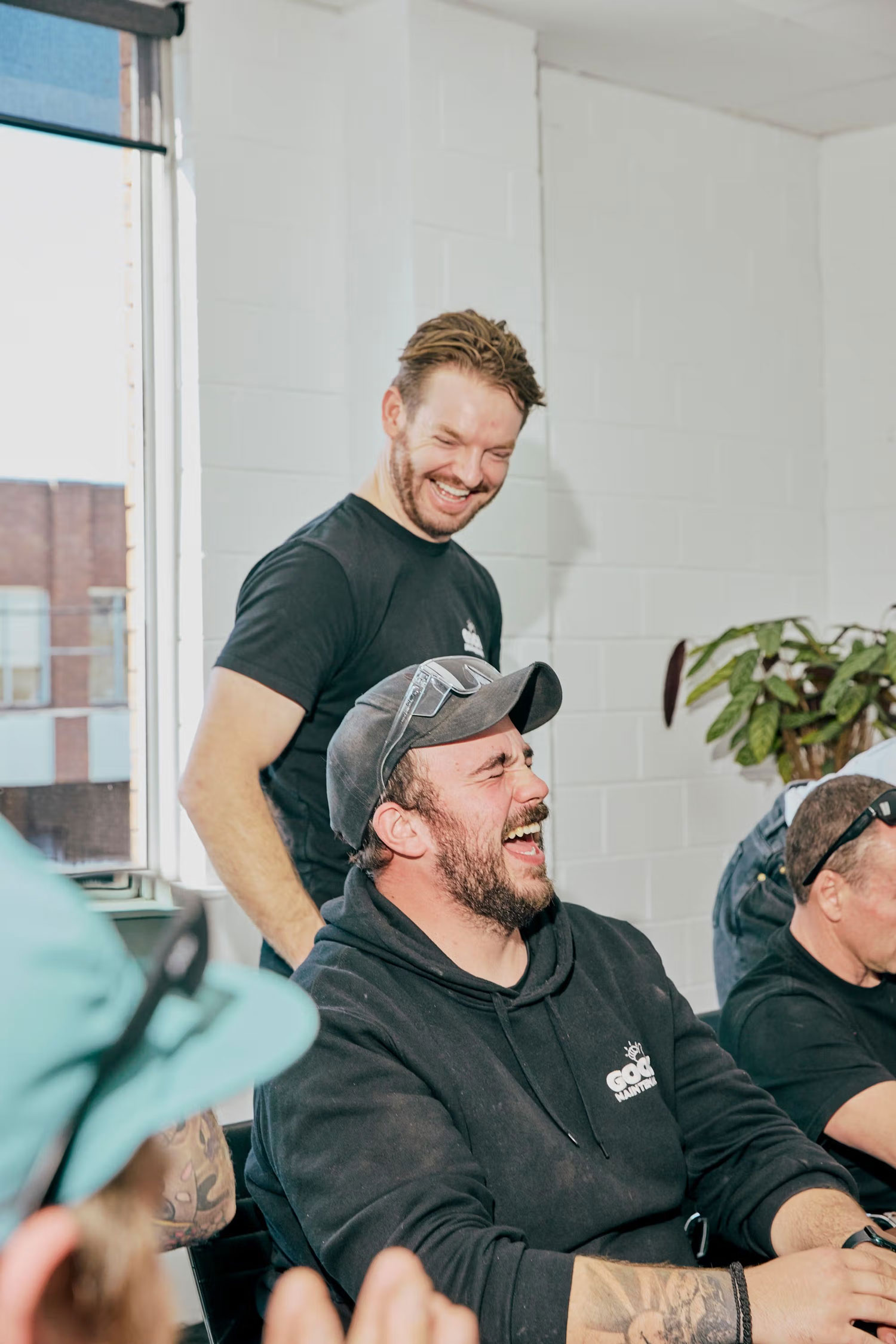 Good Maintenance team members laughing during a workshop meeting.