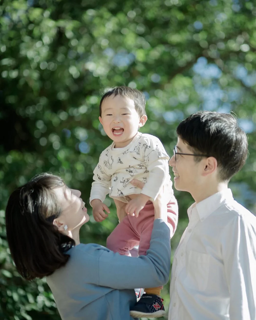 Two people installing or adjusting abstract blue artworks on a gallery wall 