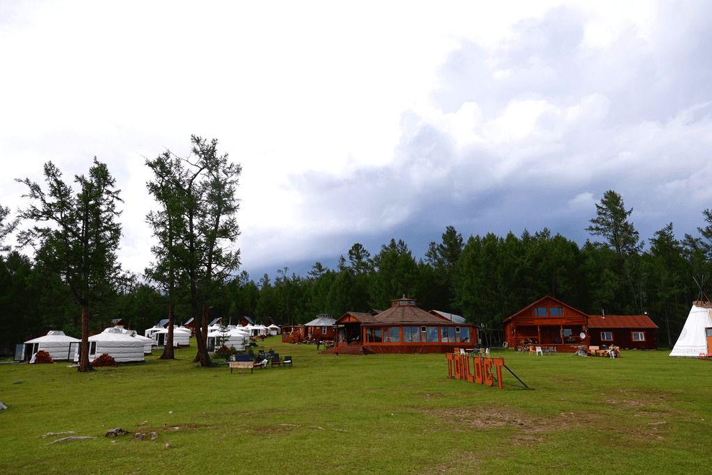 Aerial view of a winding road cutting through rocky terrain and sandy landscape.