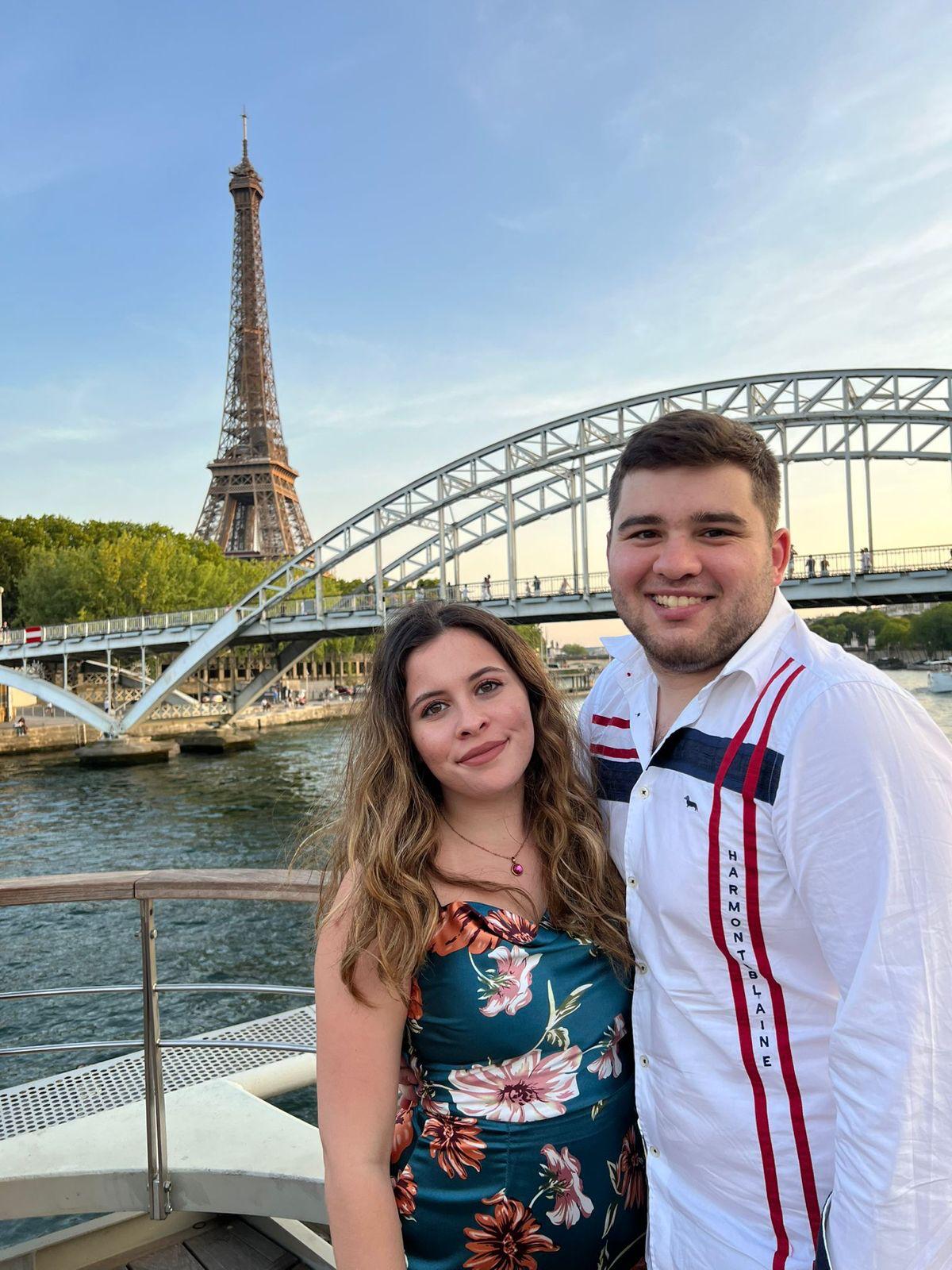 Close-up of two hands gently clasped, one wearing a sparkling engagement ring. The soft lighting and pastel nails evoke a sense of romance and intimacy.