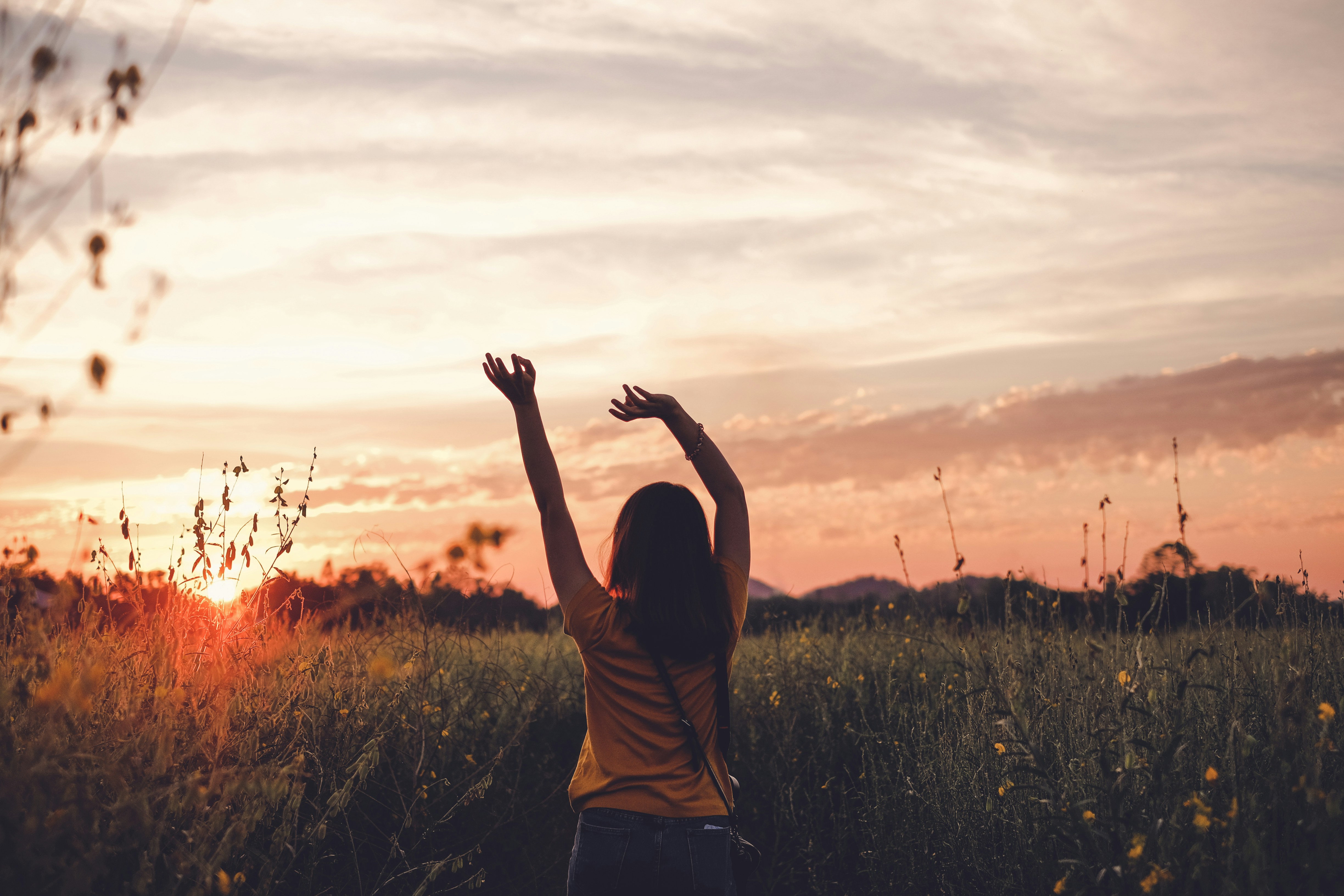 woman waving her hands during golden hour