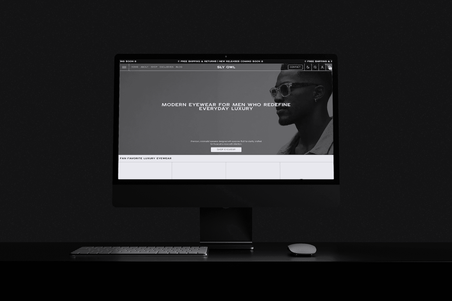 a dark room with a large monitor showcasing a white and black website selling eyewear