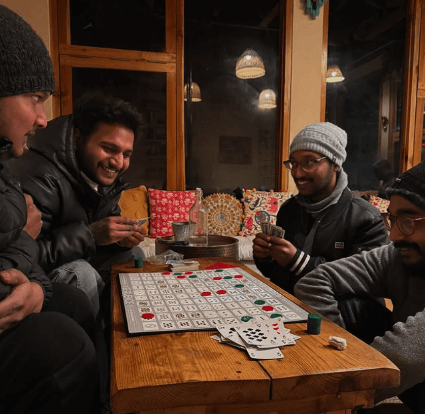 Friends laughing around a campfire in the woods