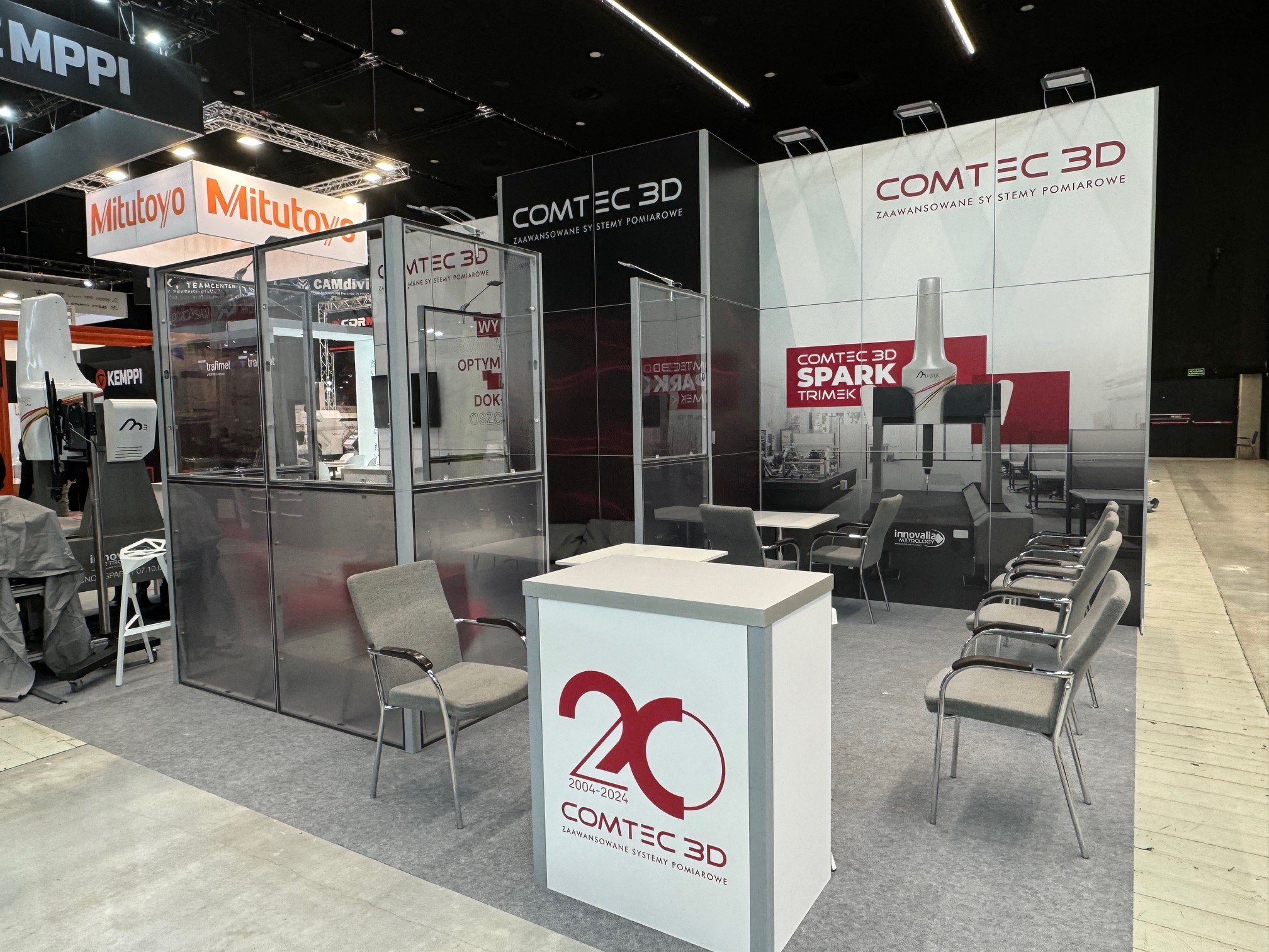 Zdjęcie z targów branżowych z dużą grafiką na ścianie