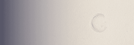 Small smear of balm spread thinly across a smooth neutral surface.