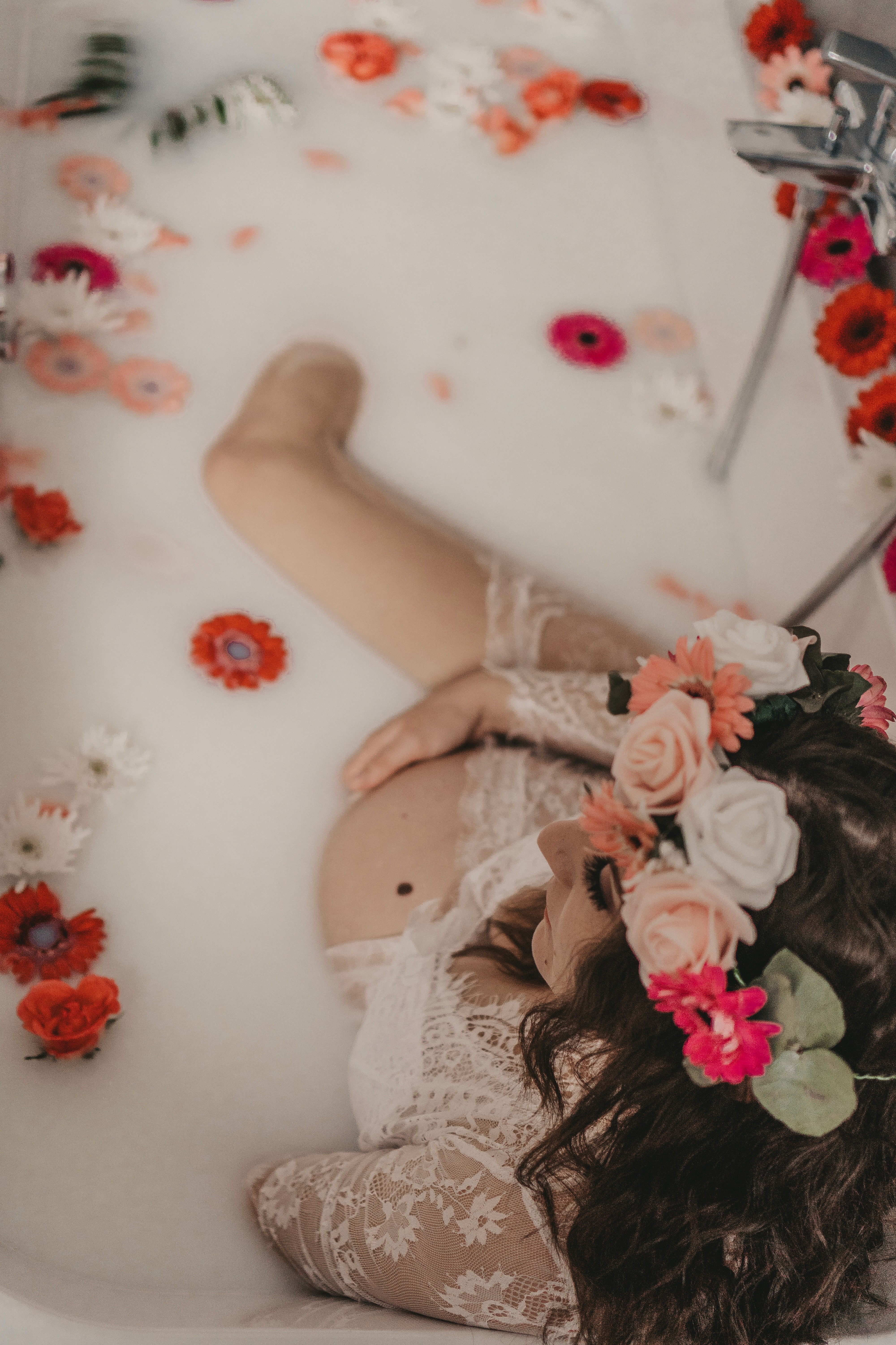 Künstlerische Hochzeitsfotografie in Bogen – Braut liegt im Wasser mit Blumen bei kreativem Shooting.