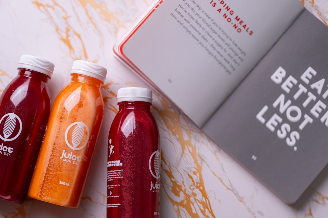 three bottles of juice next to a book