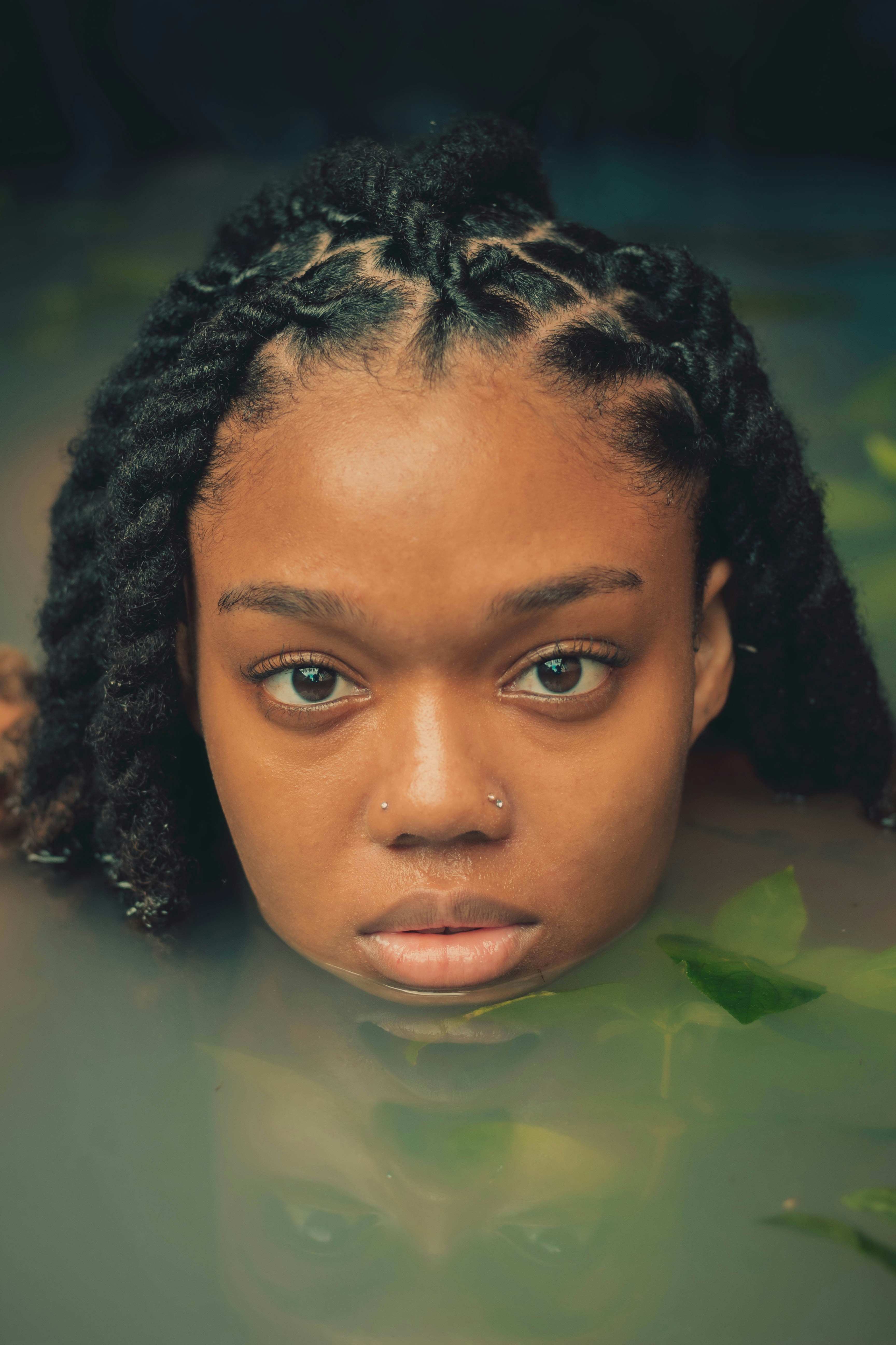 a woman with braids in a pool of water