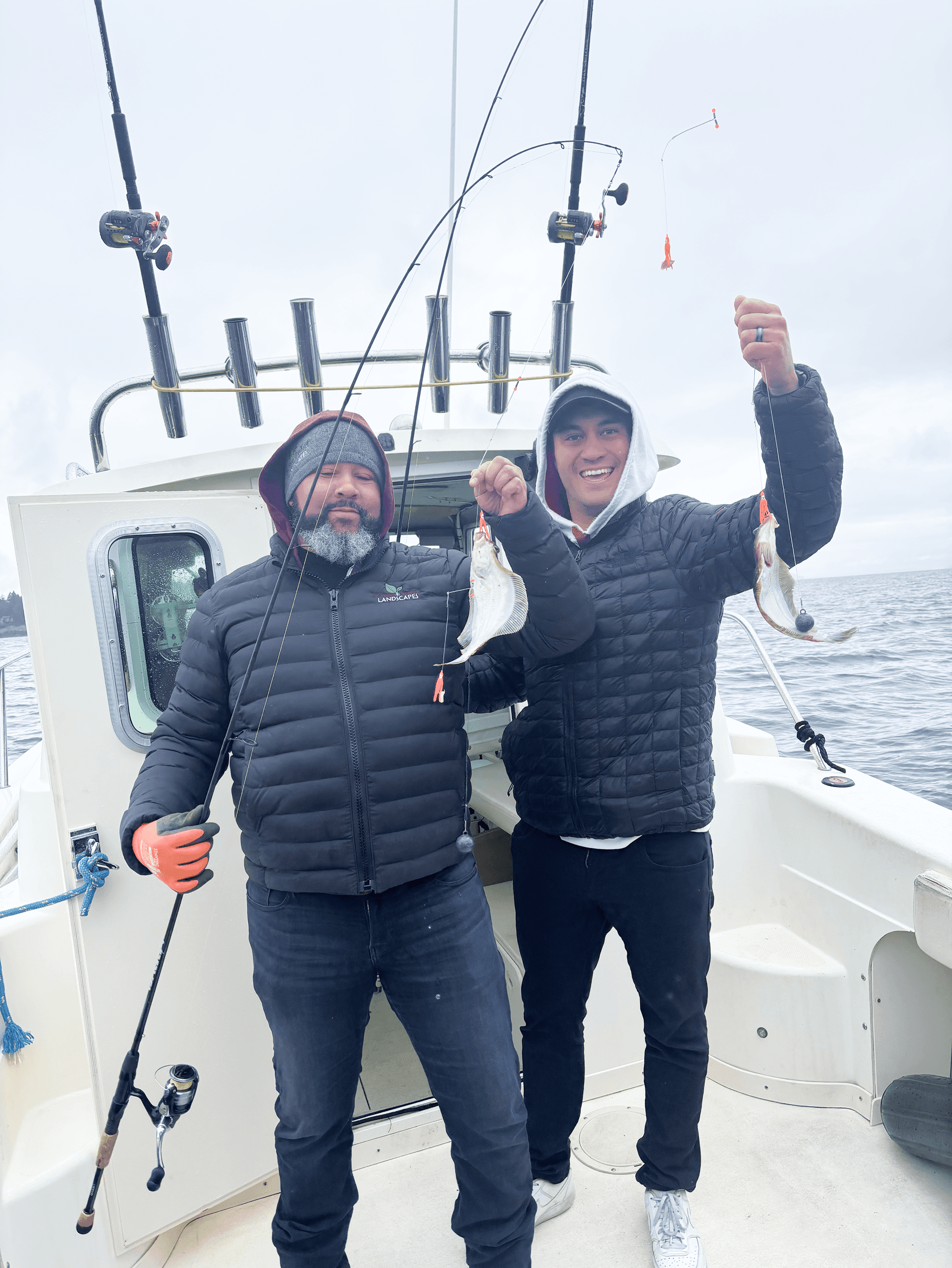 Two friends lifting salmon aboard Seattle Puget Sound charter boat.