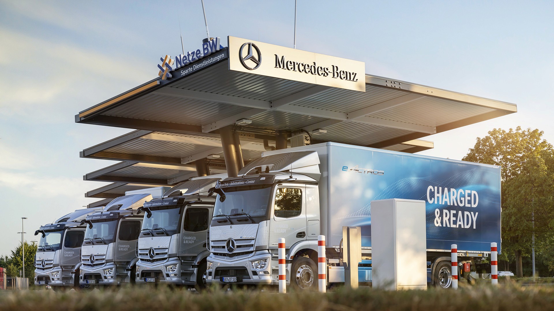 Electric trucks charging at a station, highlighting infrastructure for zero-emission freight.