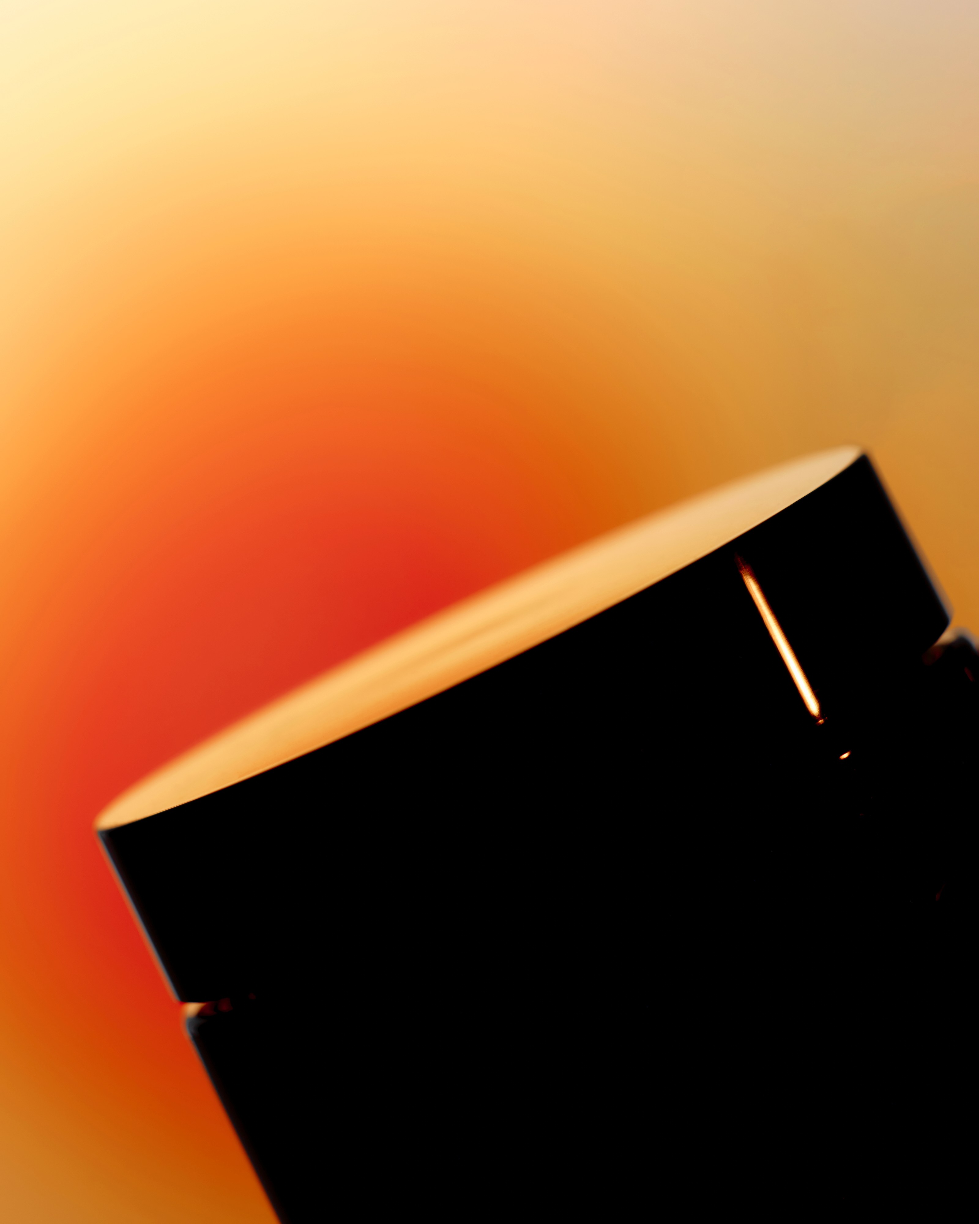 Ein enua Cannabis Aufbewahrungsglas in schwarz vor einem orangenen Hintergrund.