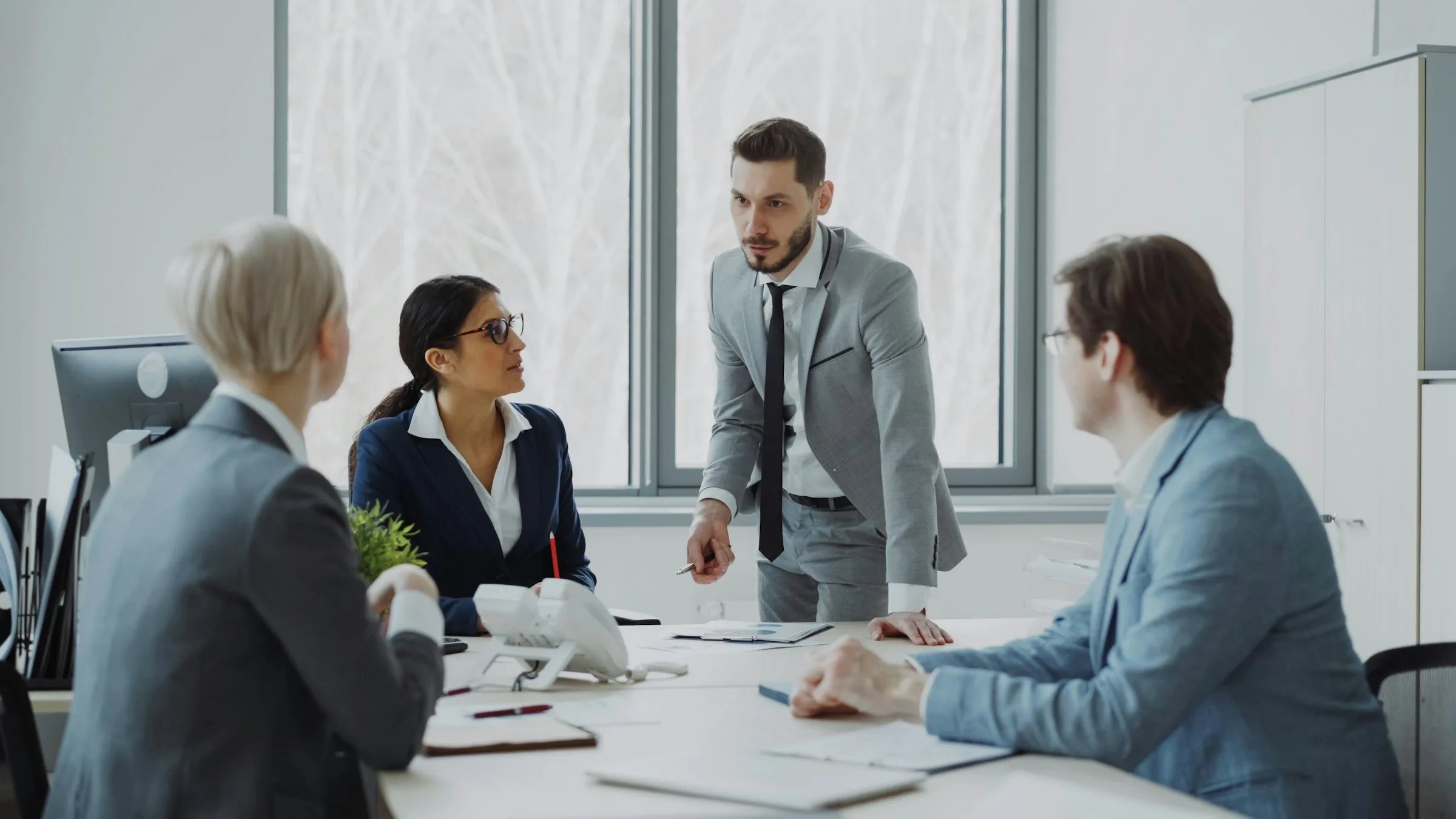 Business professionals meeting around a conference table with laptops and documents