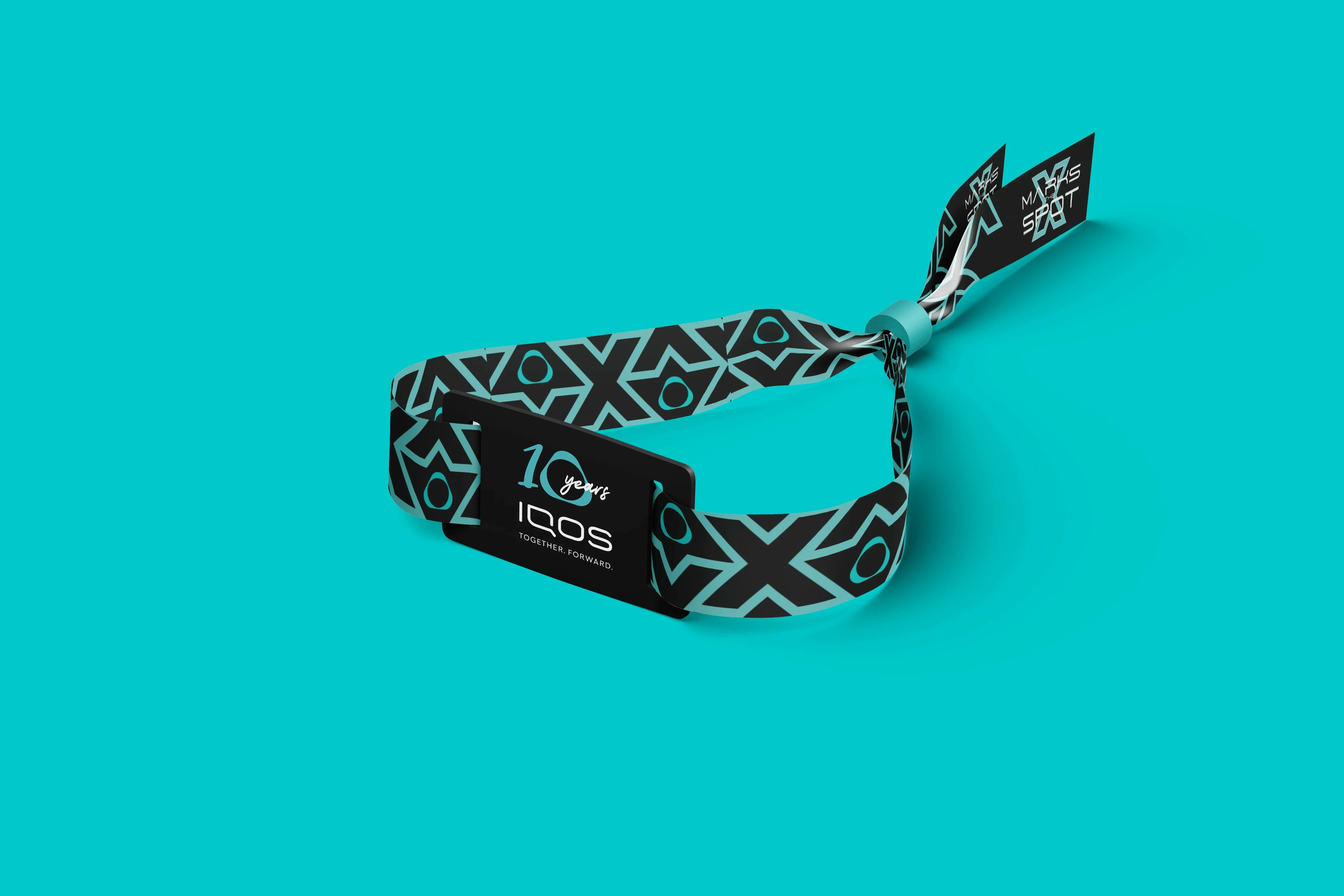 RFID event wristband design for the IQOS 10 Years celebration in Portugal, featuring the “X Marks the Spot” visual identity for a corporate brand experience event.