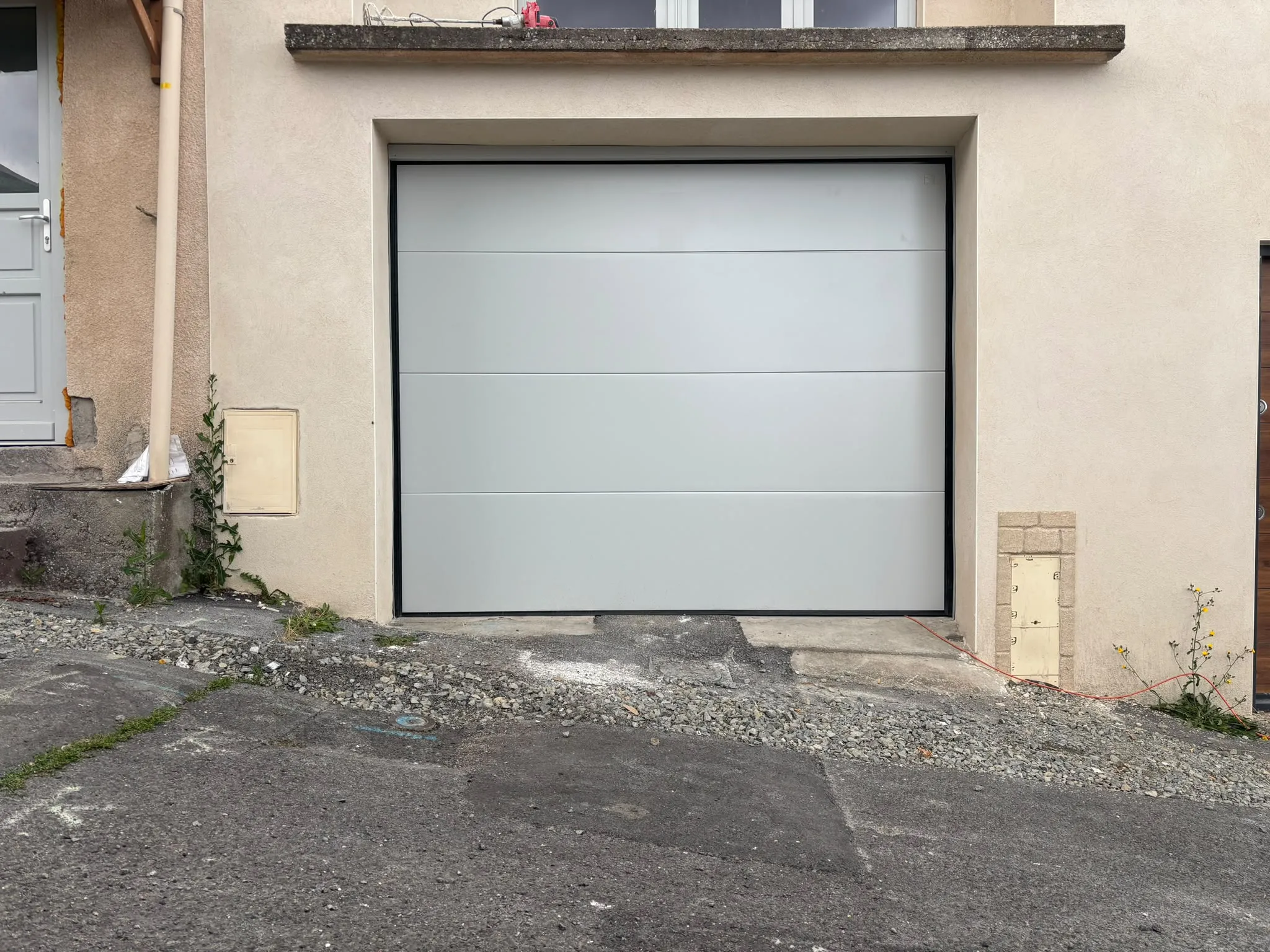 Porte de garage blanche dans une façade enduite — AFermetures