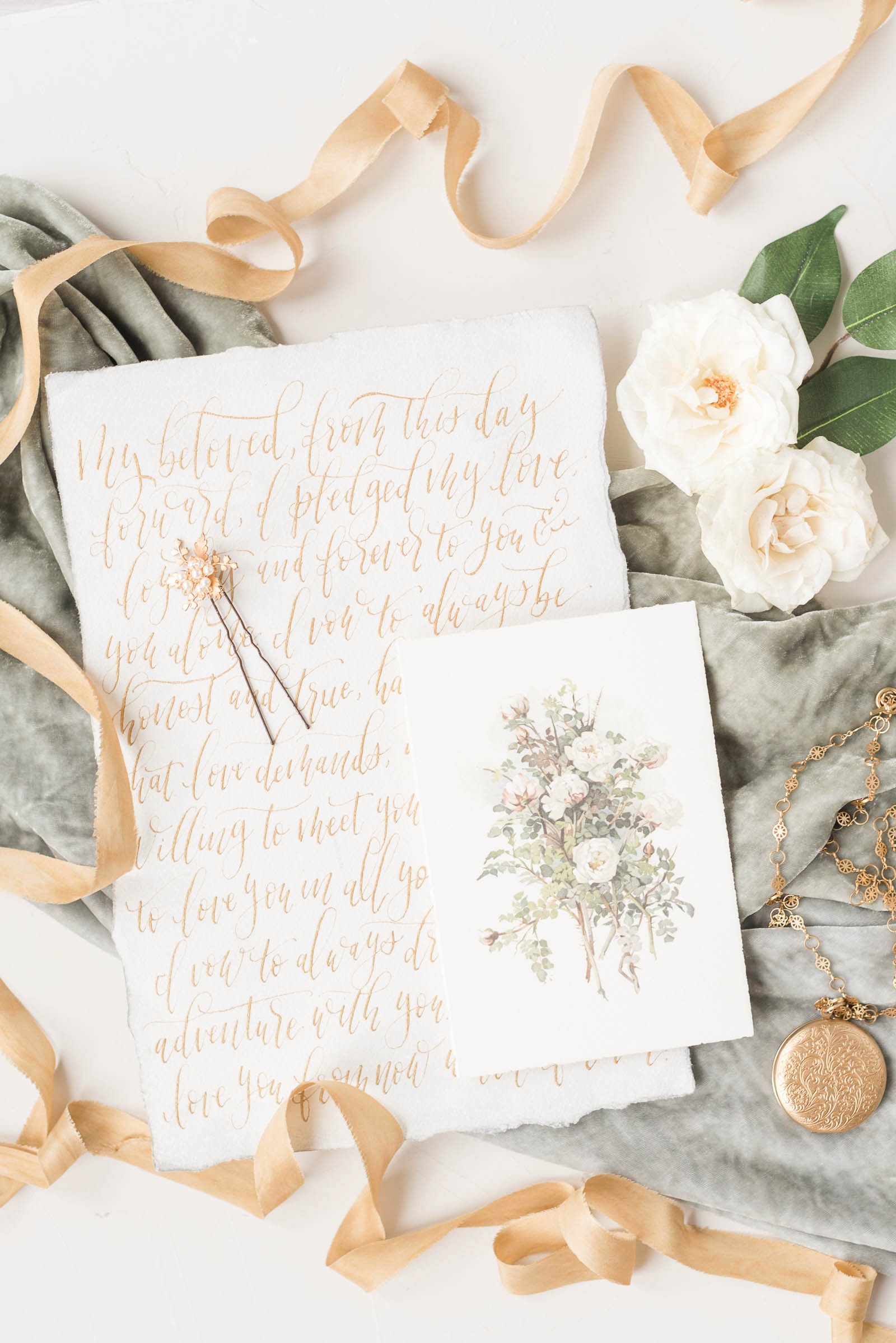 Bride and groom vows decorated with ribbon, florals, and painted flowers.