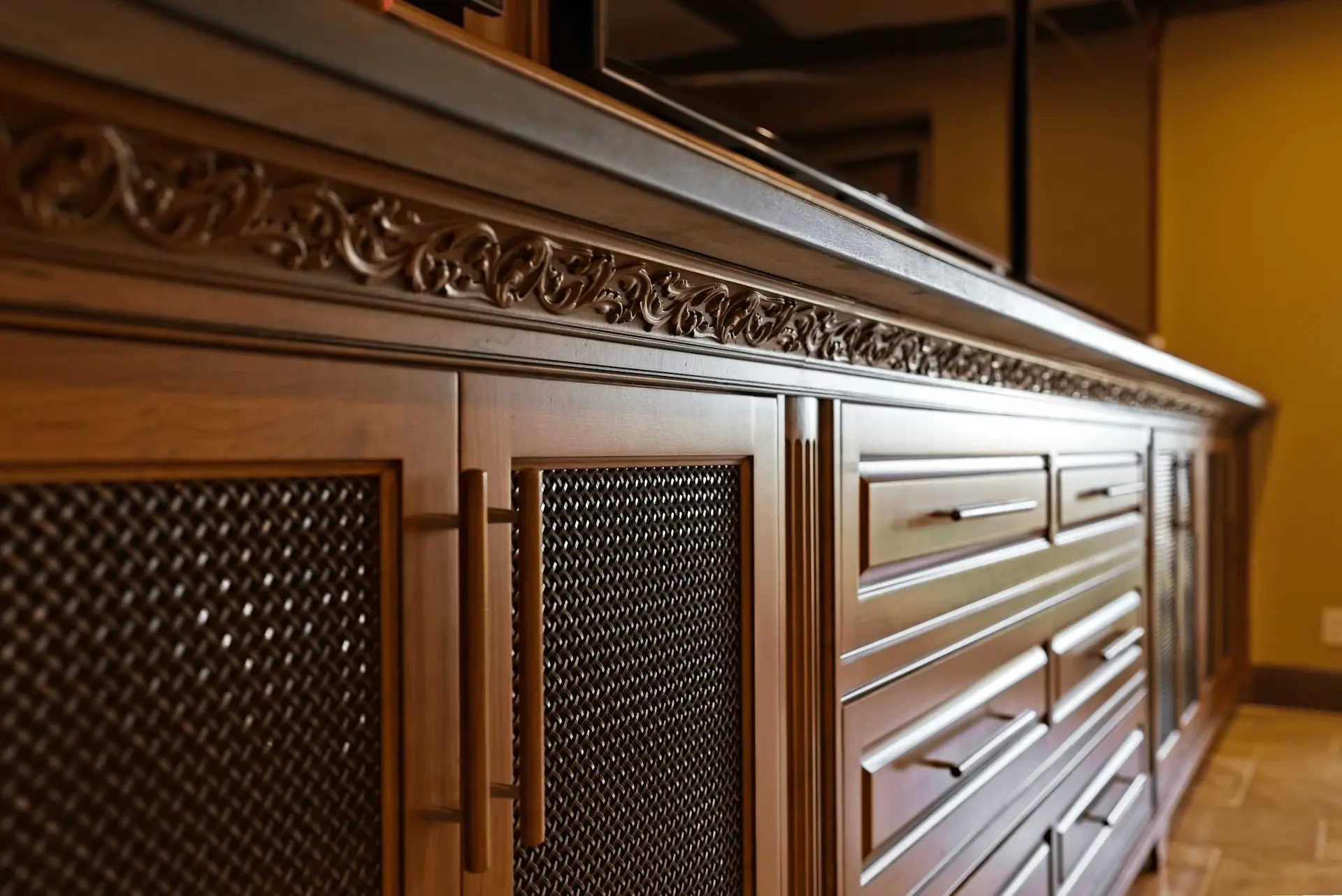 Close-up view from angle 1 of the custom entertainment cabinetry, showcasing intricate woodwork and design in the San Juan Capistrano entertainment room. Photo by Todd Huge.