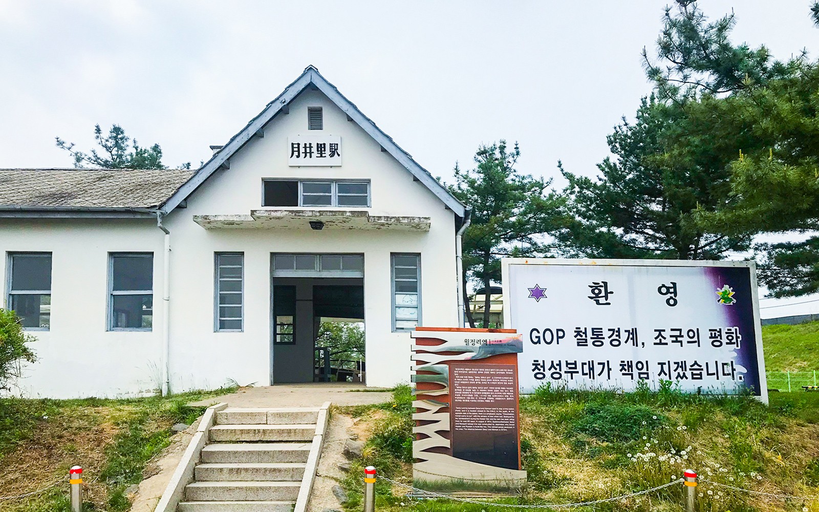 Old train station at the DMZ in Paju, South Korea, with welcome sign and trees.