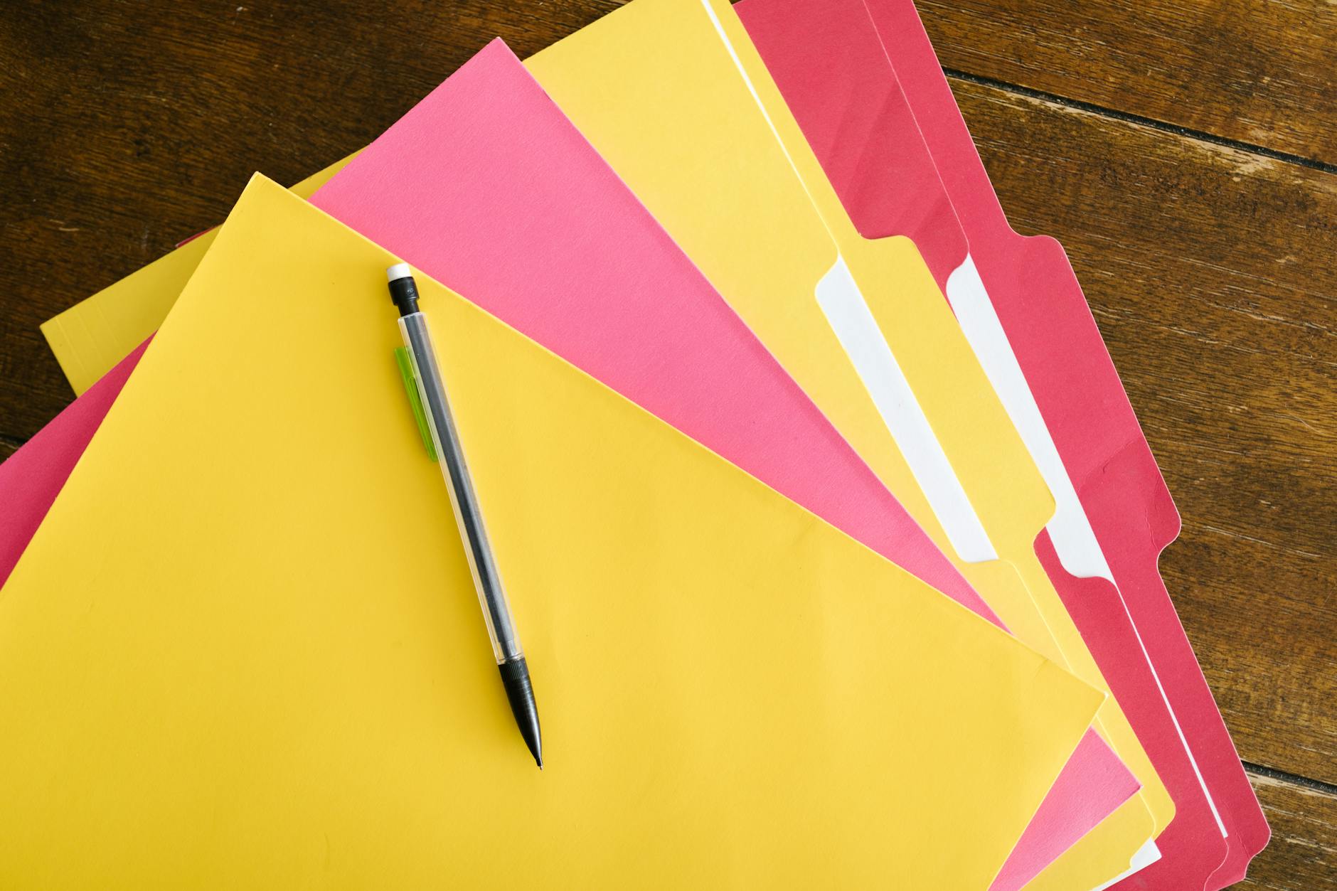 Five colorful sticky notes arranged neatly on a wooden desk representing the core components of a teaching module.