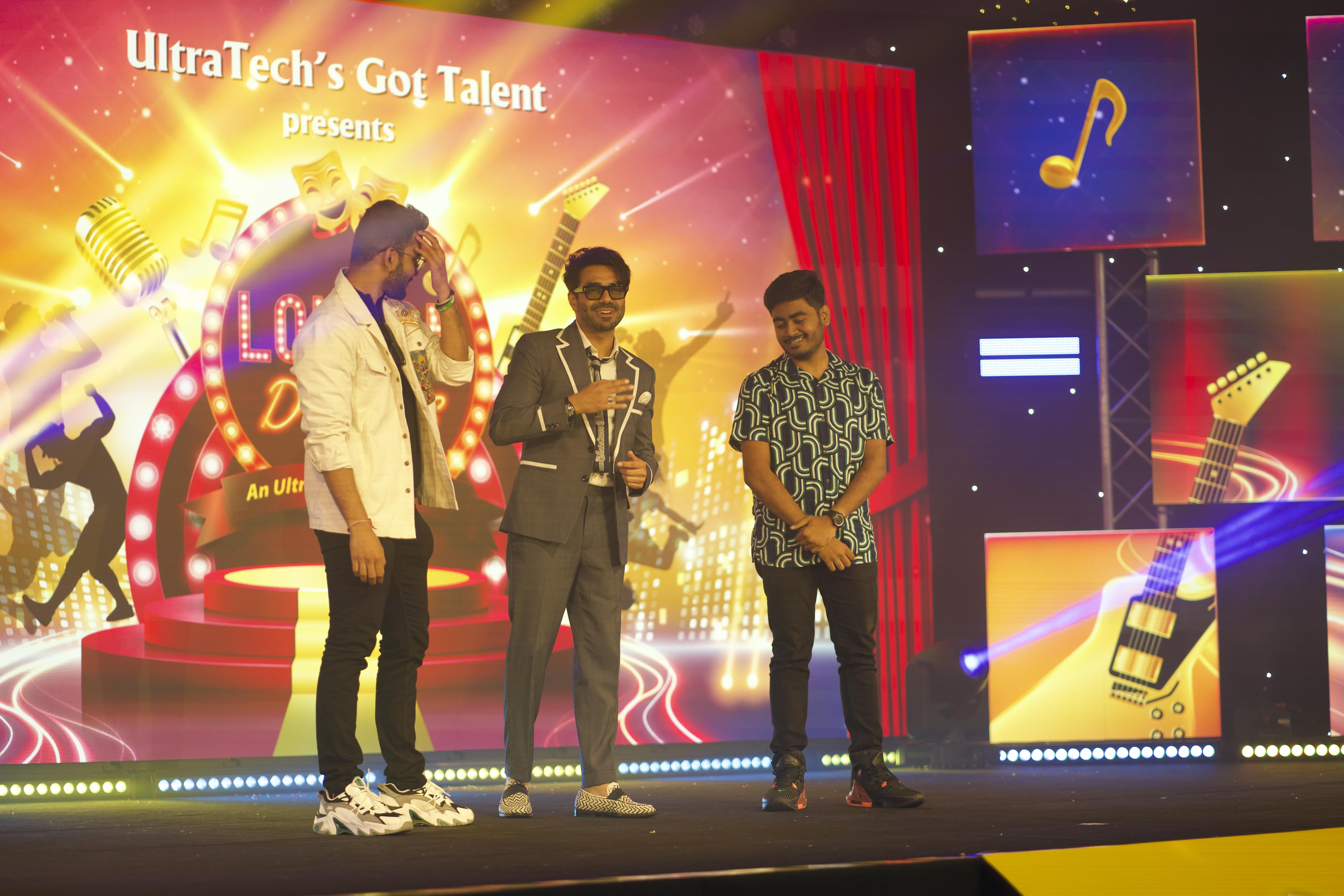 Three presenters on the UltraTech’s Got Talent stage in front of the central LED wall.