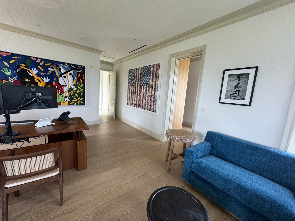 Living room with a colorful abstract painting and a black-and-white surfing photograph on opposite walls