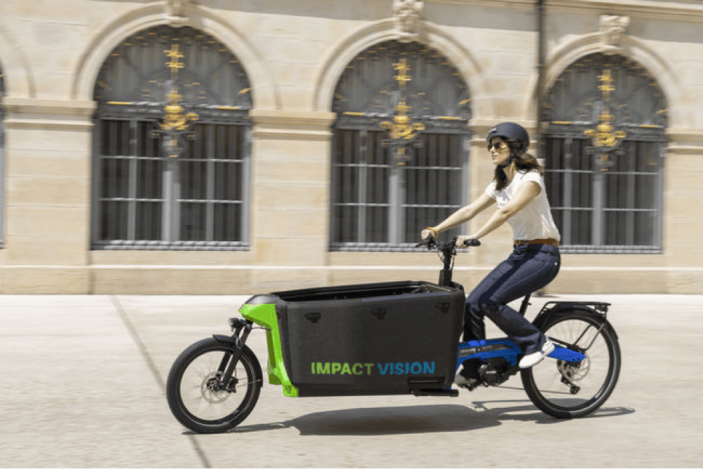 Femme en vélo cargo Impact Vision roulant en ville