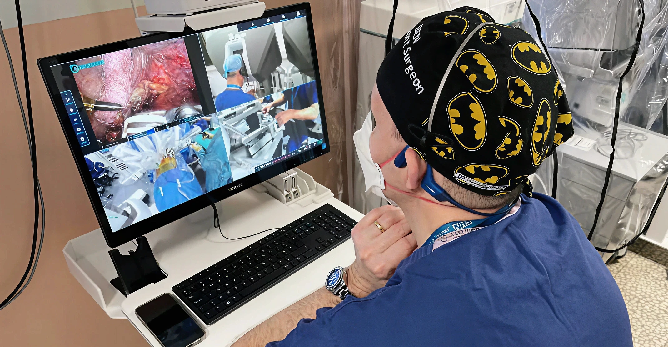 emote surgeon monitoring live laparoscopic and robotic surgical video feeds on a Proximie-style telementoring display for remote surgical guidance