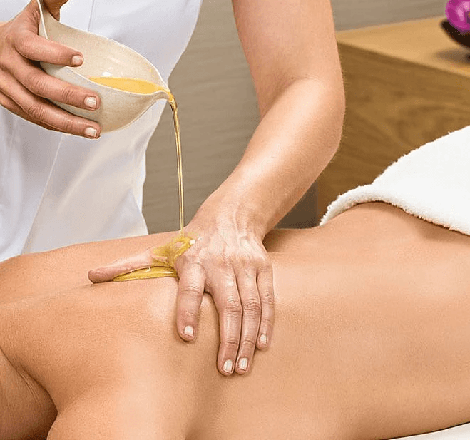 A woman receives a relaxing energy healing in a serene setting with soft lighting.