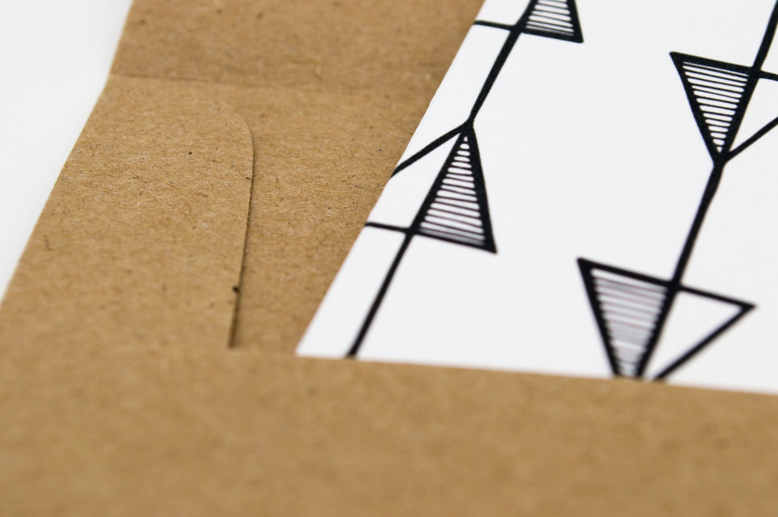 Close-up of a folded kraft-card packaging edge with printed triangle graphics