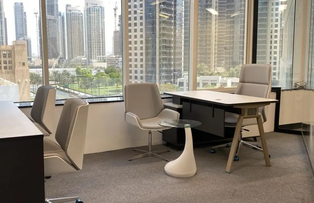 Modern office interior with floor-to-ceiling windows offering scenic views of Business Bay skyline.