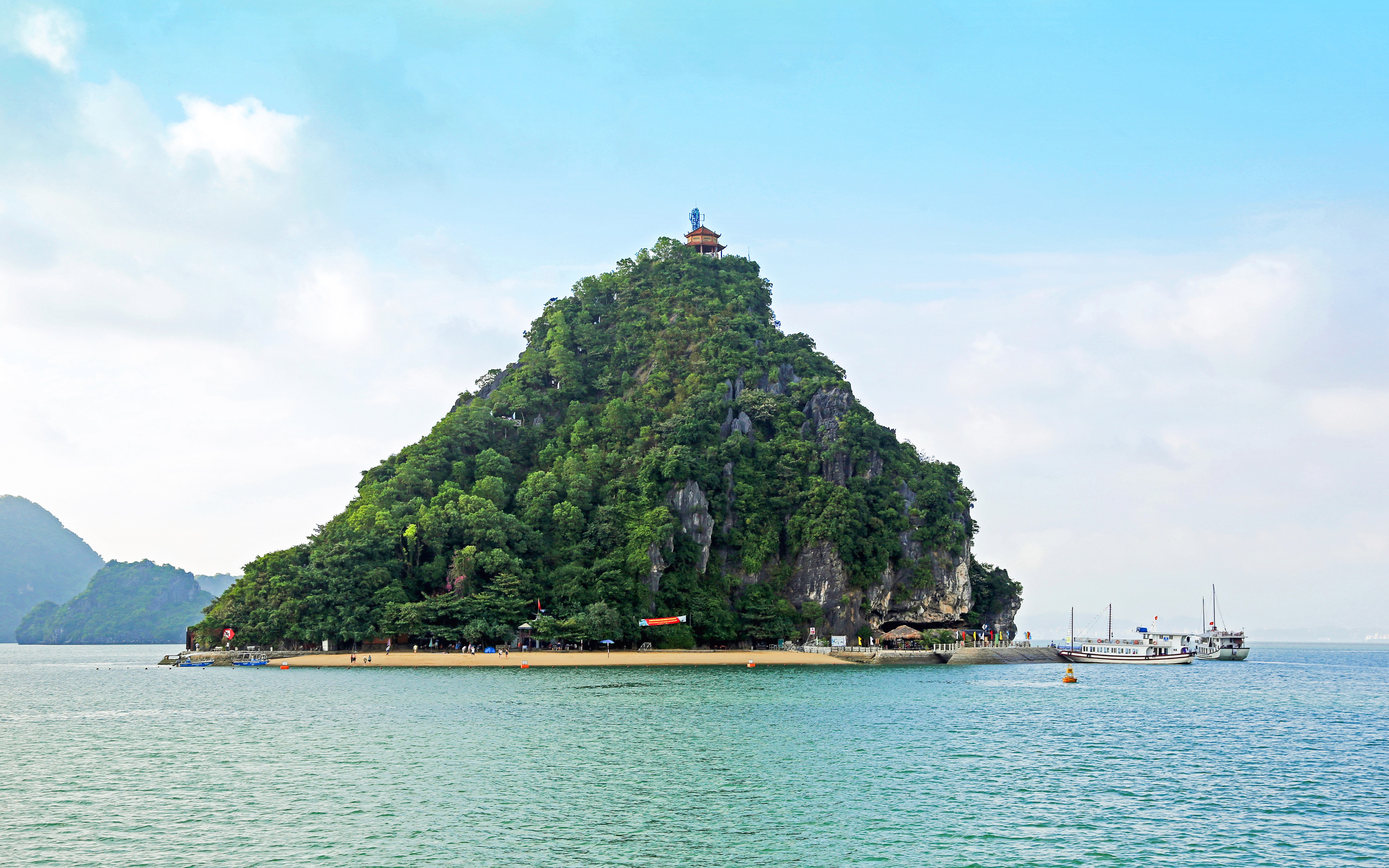 访问位于下龙湾的提托普岛,背景是游船和石灰岩。