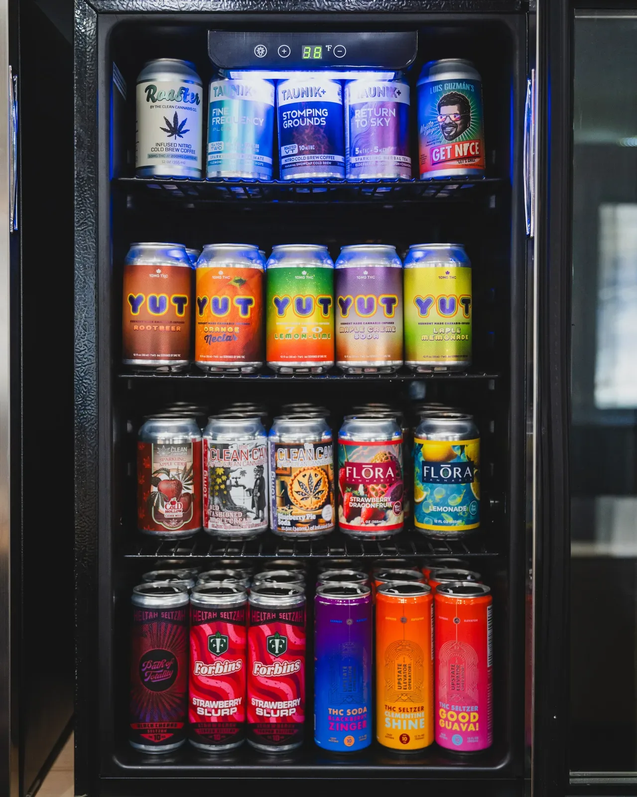 Refrigerator display of cannabis-infused beverages at a Vermont dispensary including seltzers, tonics, and flavored drinks