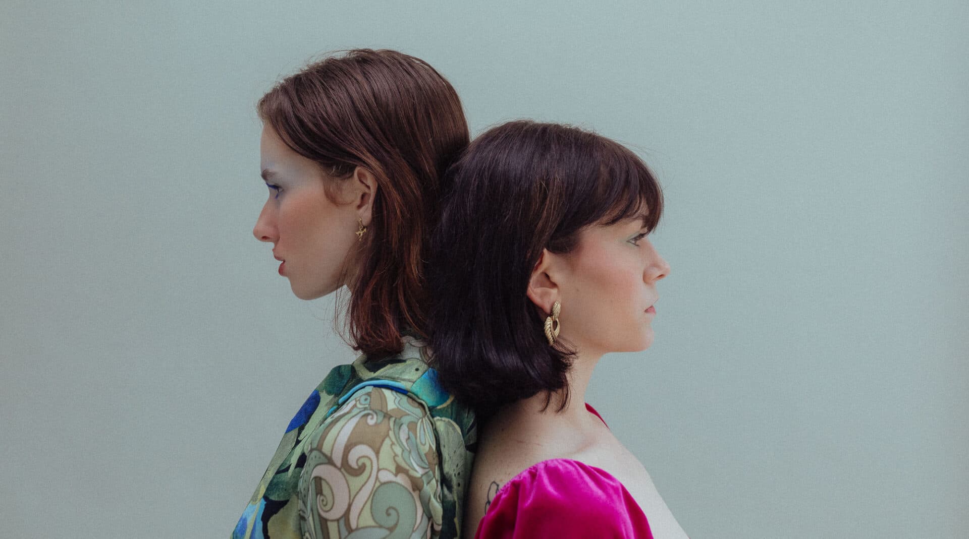 Two women sitting back to back