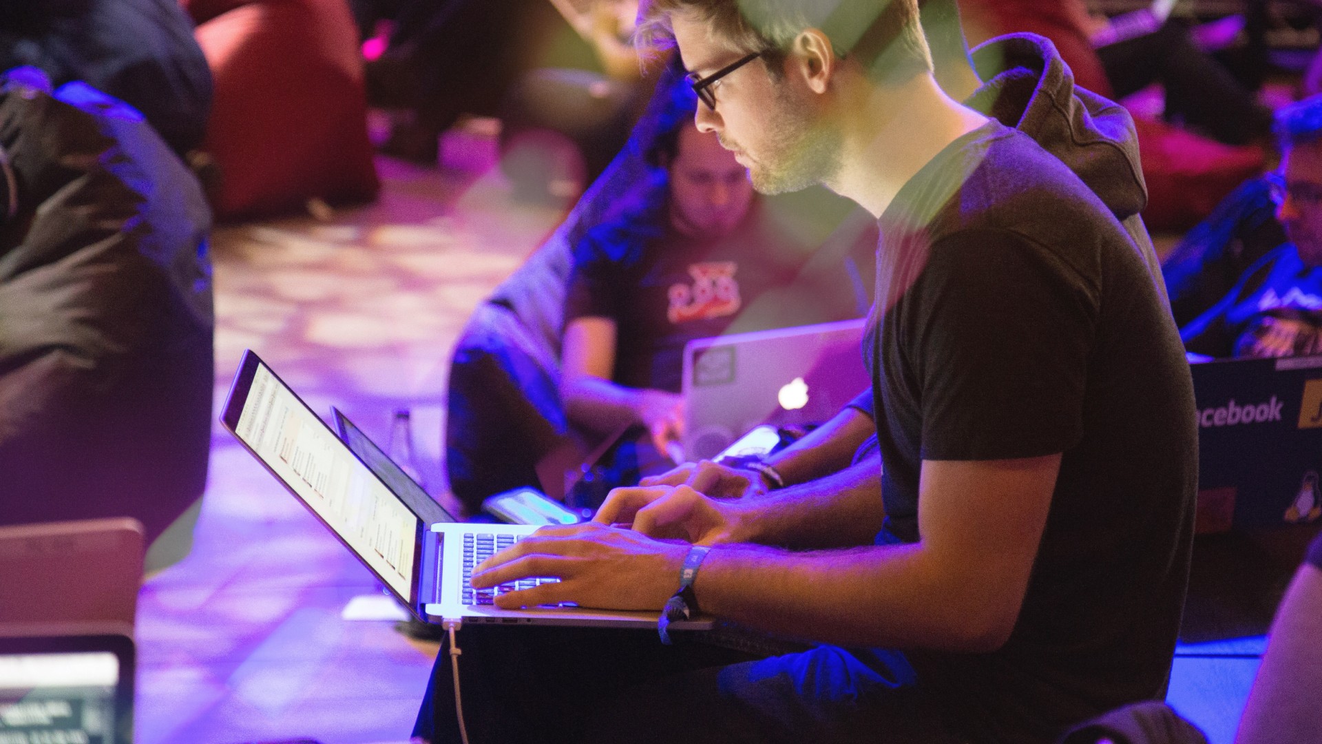 A man sits in a casual space on his laptop