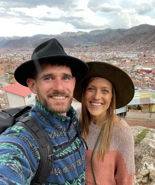 Bre and Flo smiling together towards the camera in a warm candlelit room.