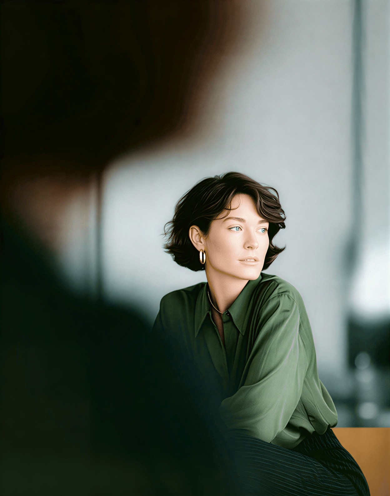 Woman in green shirt looking away during a professional meeting.