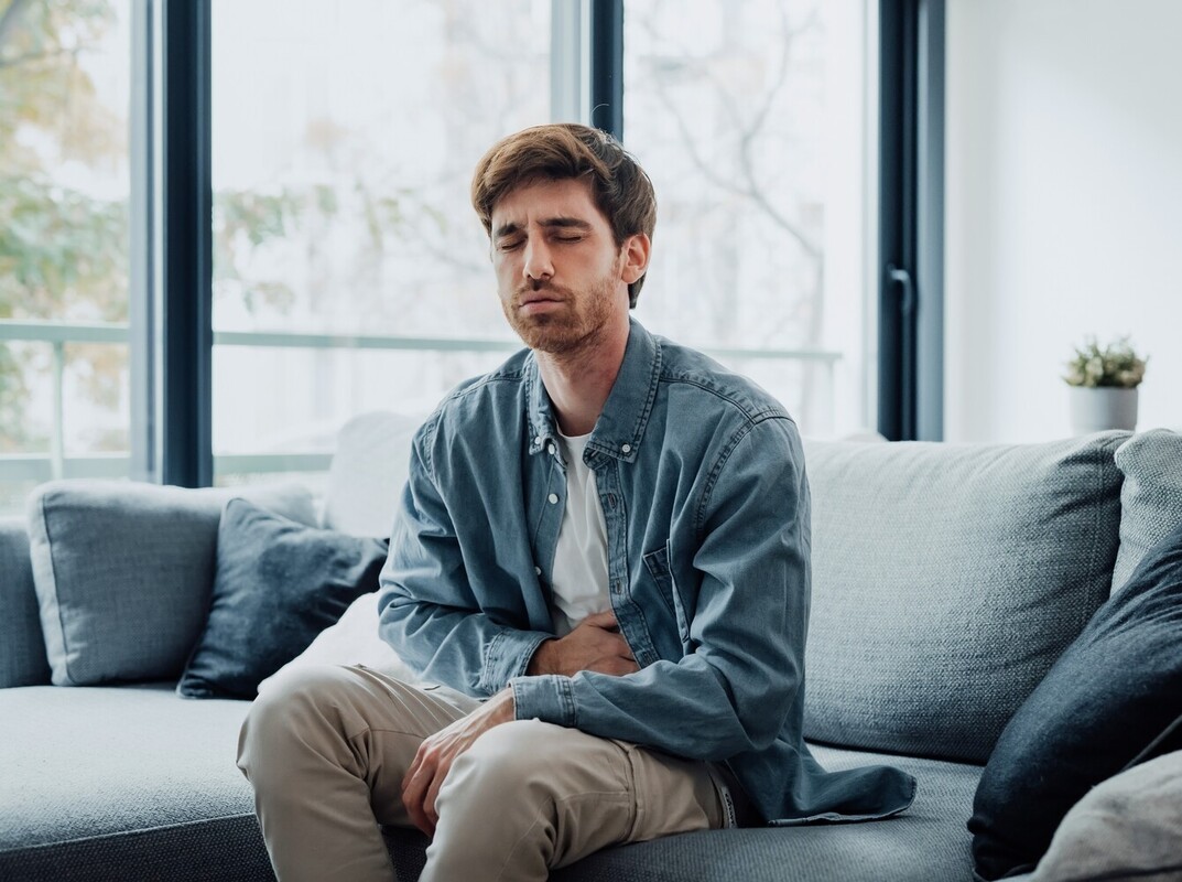 man feeling ill from taking a herbal weight control pill with false advertising