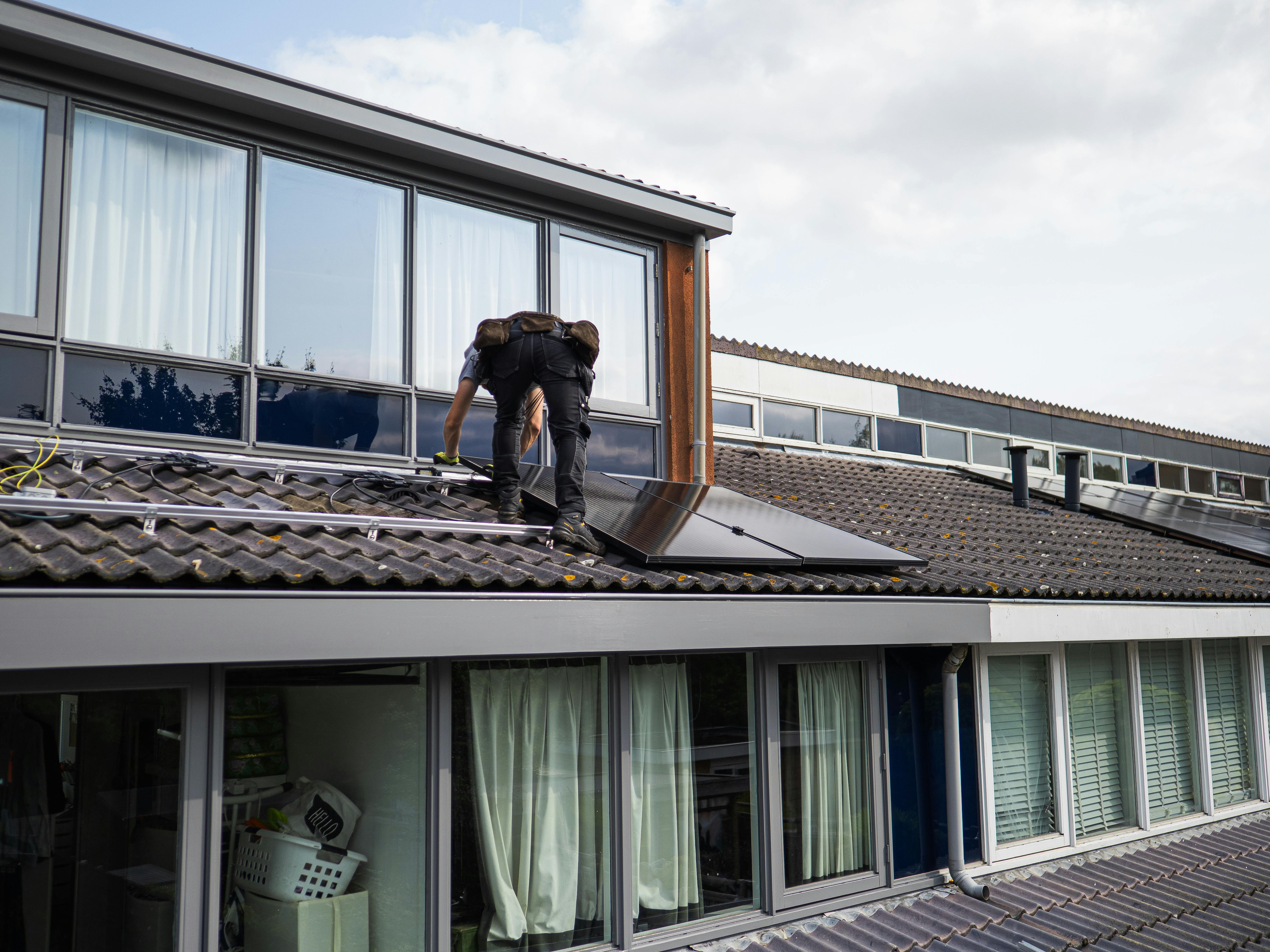 Zonnepanelen worden op een dak gebouwd
