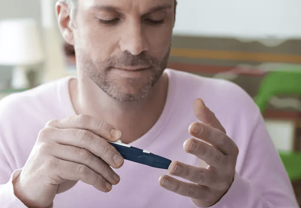 man checking blood sugar level as part of managing type 2 diabetes